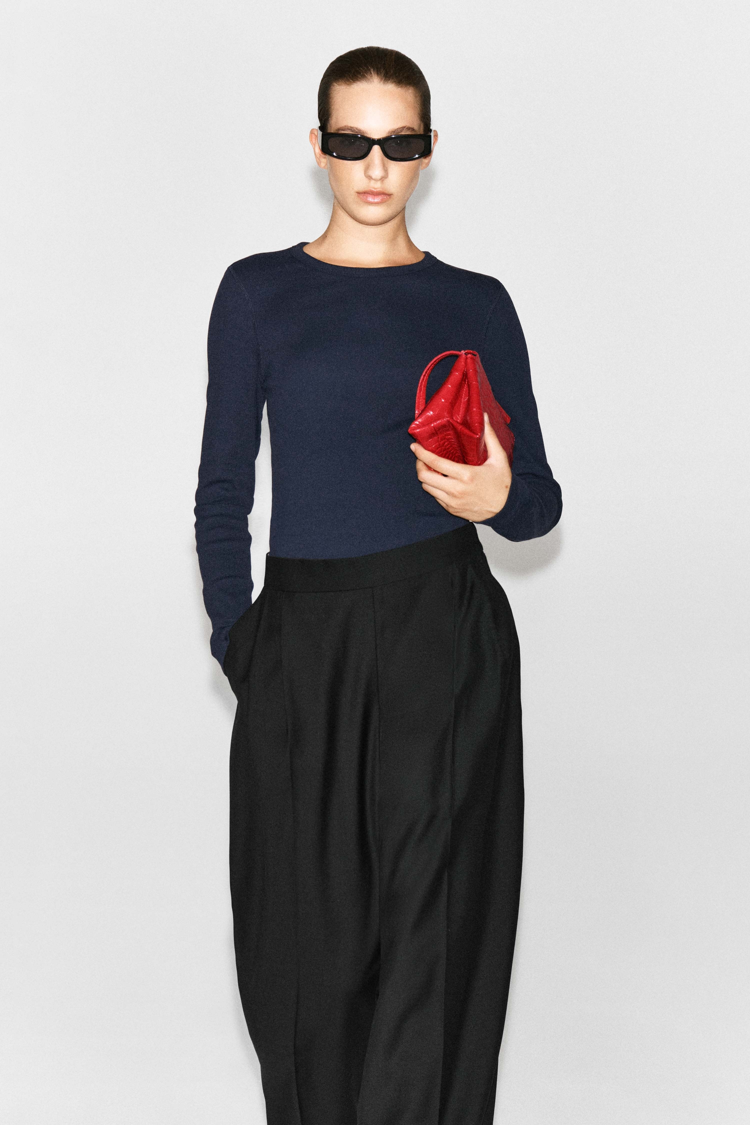 Questo top a maniche lunghe in cotone a costine, slim fit, di colore blu navy, Ã¨ mostrato in una vista frontale, mettendo in risalto la sua fine trama a maglia a costine, lo scollo tondo e la silhouette aderente. Il top presenta maniche lunghe applicate e un orlo dritto.