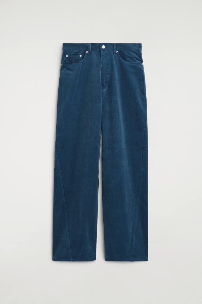 The Facade corduroy straight-leg jeans are shown from the front, showcasing a deep teal blue colour and a textured ribbed corduroy fabric. The jeans feature a classic five-pocket design, a metal button fastening at the waistband, and distinctive curved seams running along the outer sides of the straight legs. - 1