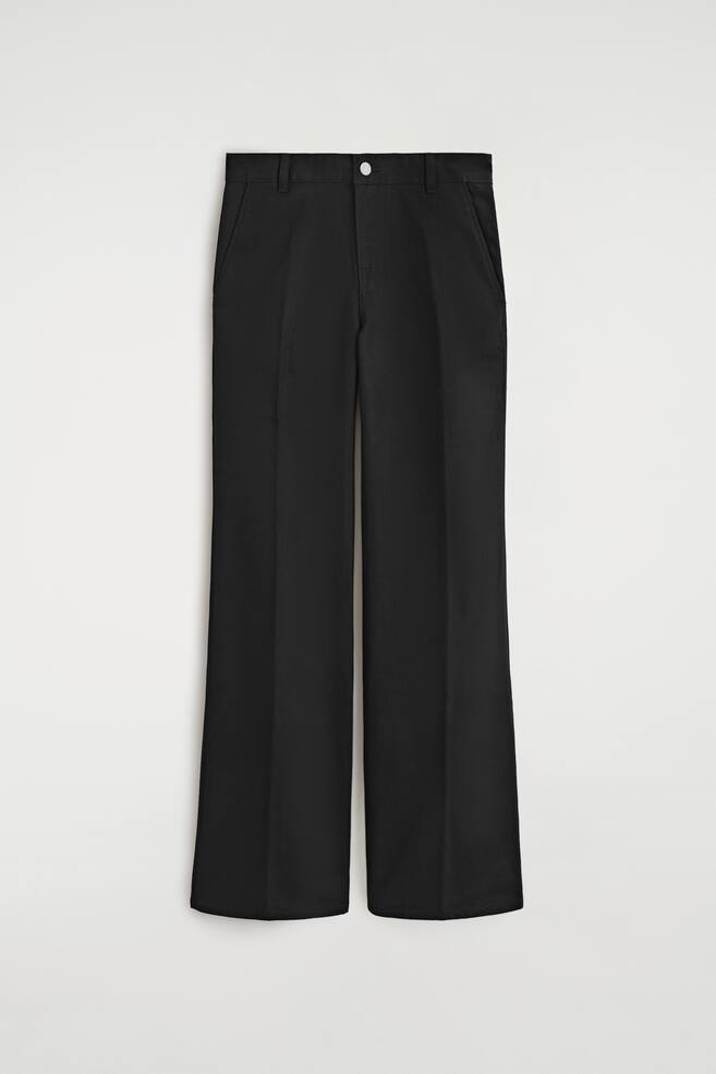 Eine schwarze Baumwoll-Jeanshose ist von vorne zu sehen und prÃ¤sentiert eine gerade Silhouette mit gebÃ¼gelten BÃ¼gelfalten entlang jedes Hosenbeins. Die Hose verfÃ¼gt Ã¼ber einen Bund mit GÃ¼rtelschlaufen, einen silberfarbenen Knopfverschluss und seitliche Eingrifftaschen. - 1