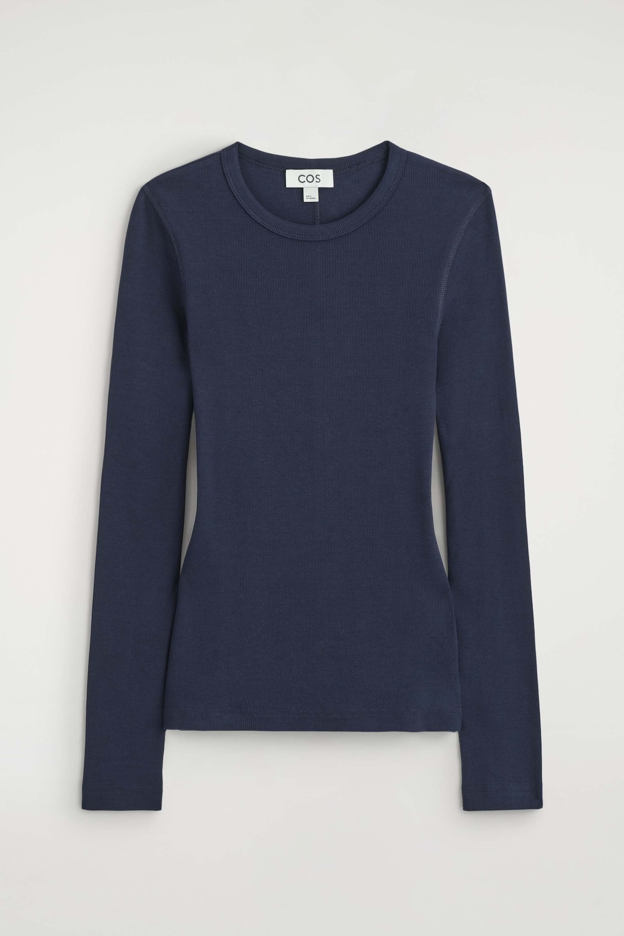 This navy blue slim-fit ribbed cotton long-sleeved top is shown from the front, highlighting its fine ribbed knit texture, crew neckline, and slim silhouette. The top features long set-in sleeves and a straight hem.