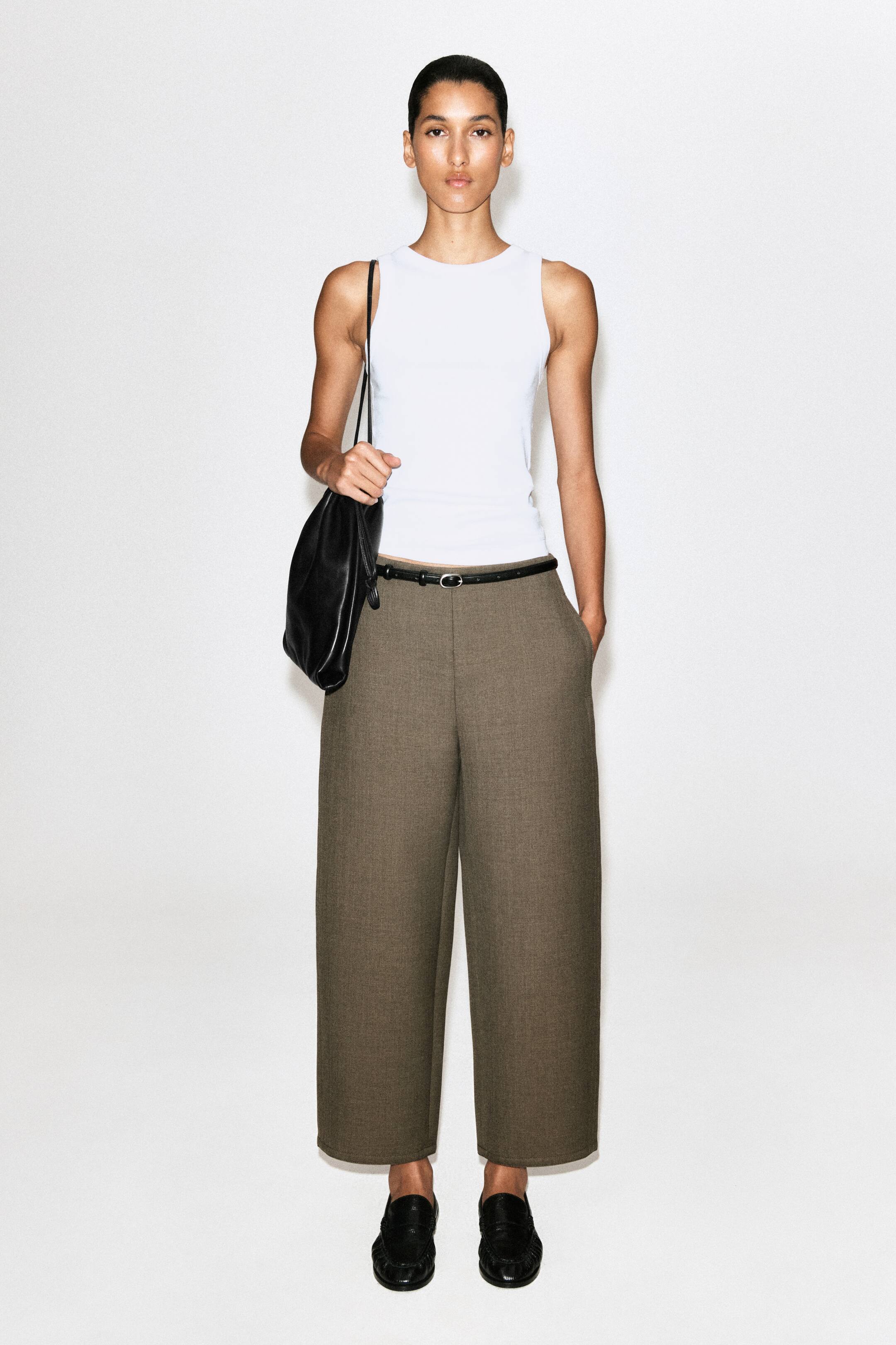 Grotere afbeelding bekijken: Deze twill broek van wolmix wordt van voren getoond, met een cropped barrel-leg silhouet in een getextureerde taupebruine stof. De broek valt normaal in de taille, heeft zijzakken en is gestyled met een smalle zwarte riem.