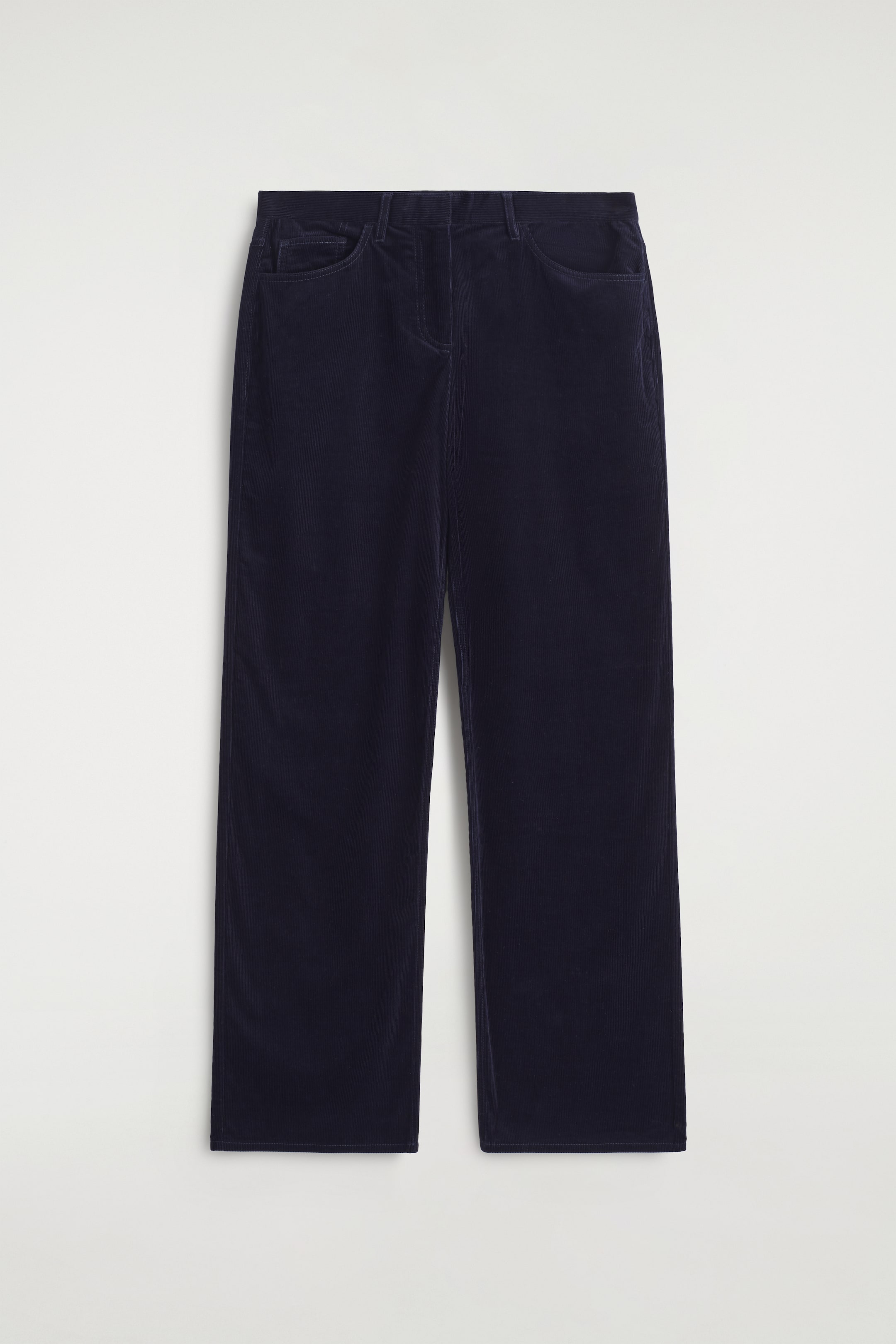 Größeres Bild ansehen: Ein Paar dunkelblaue Cordhosen wird flach präsentiert und zeigt die Vorderansicht. Die Hose verfügt über einen glatten, flachen Bund, zwei sichtbare Schlitztaschen und einen geraden Beinabschluss.