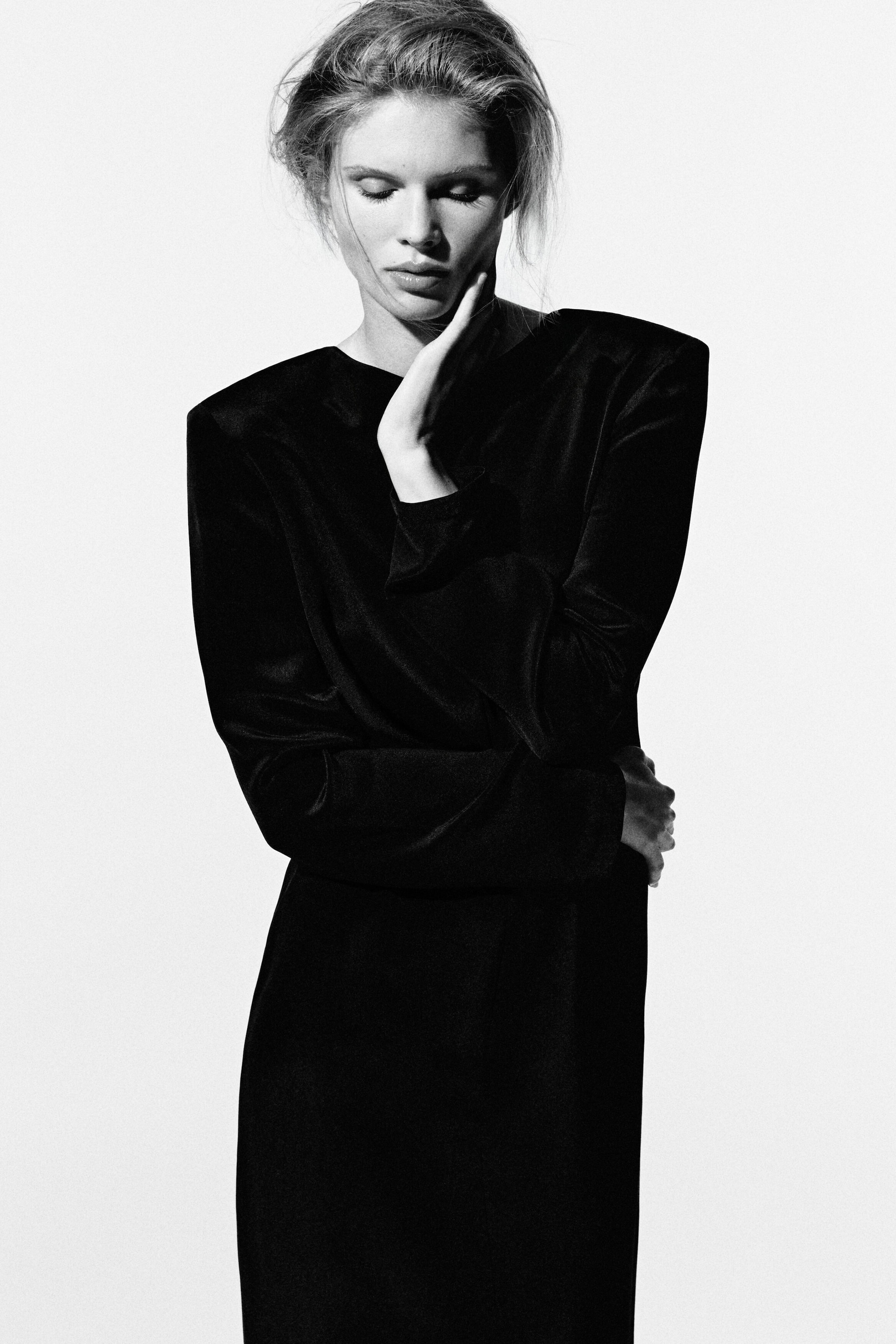 The button-detail silk crepe maxi dress showcases a structured silhouette from the front, featuring padded shoulders, a crew neck, and long sleeves. The button-detail silk crepe maxi dress showcases a structured silhouette from the front, featuring padded shoulders, a crew neck, and long sleeves.