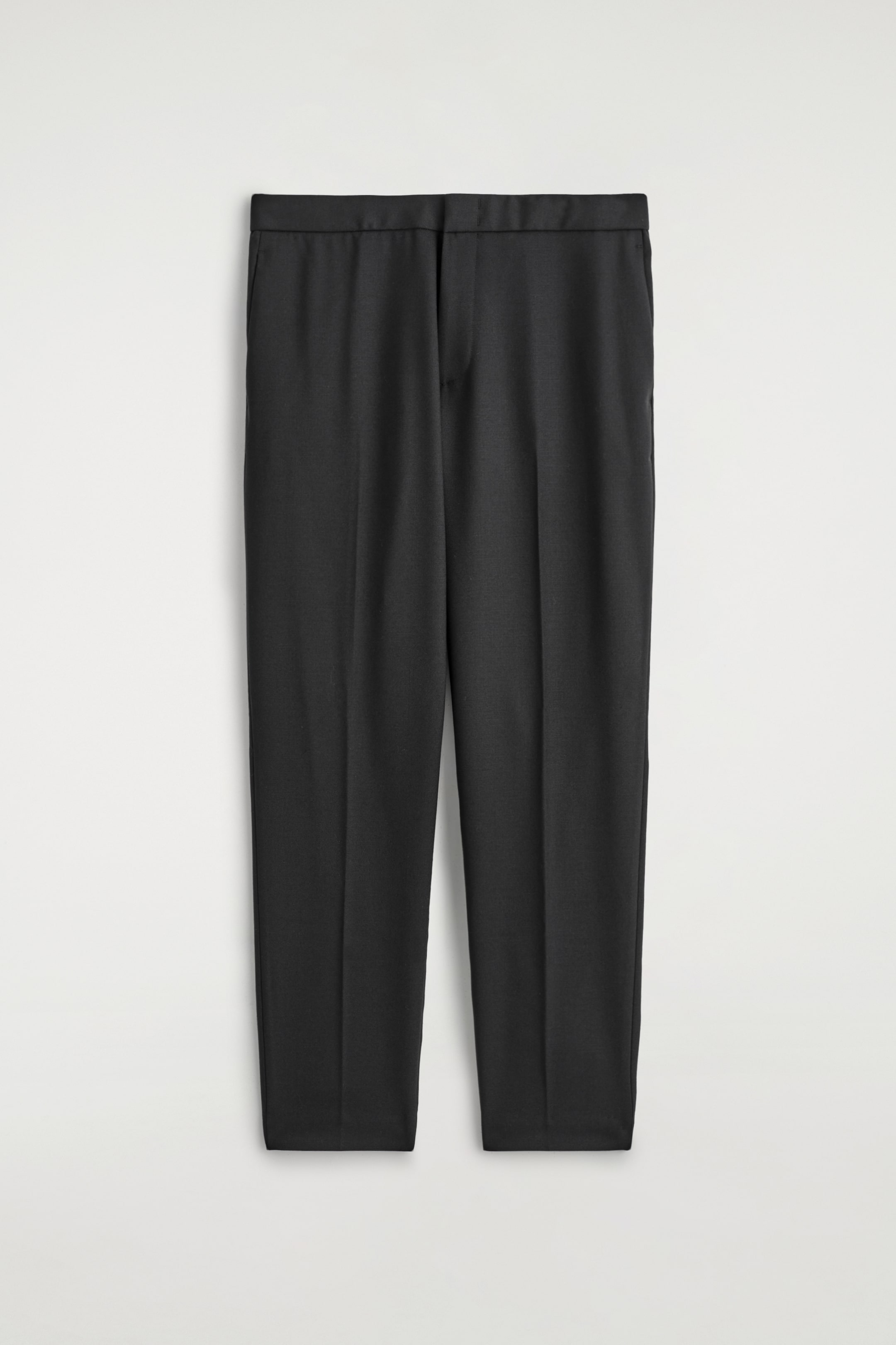 Visualizza immagine più grande: Un paio di pantaloni skinny-fit blu navy sono esposti dalla parte ANTERIORE, mostrando una cintura semplice, una chiusura a gancio, barra e zip, e tasche laterali. Pieghe sono visibili lungo la parte anteriore di ciascuna gamba.