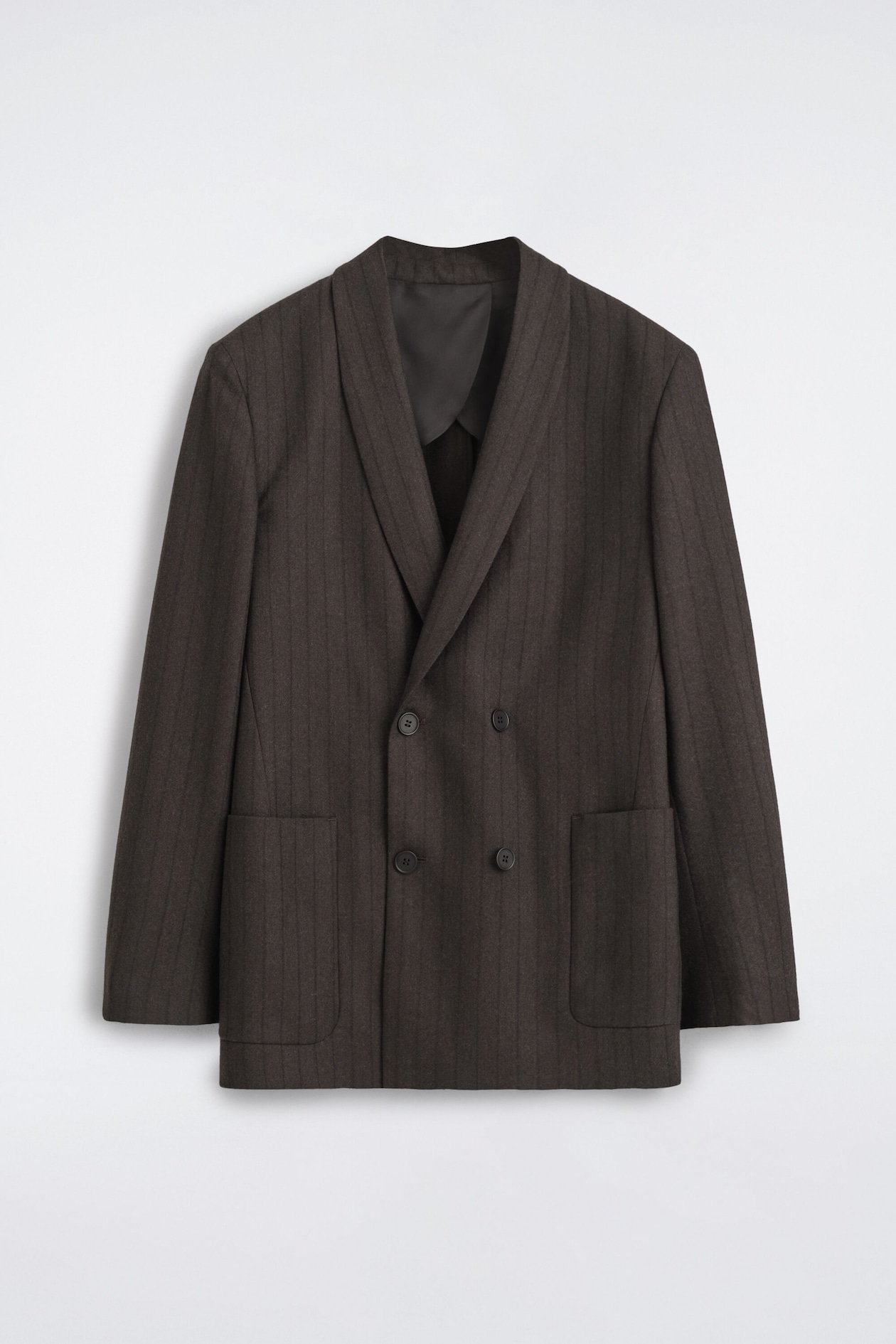 A dark brown double-breasted blazer in a subtle pinstripe pattern is shown from the front, featuring a relaxed fit, a shawl collar, a four-button closure, and two large front patch pockets.