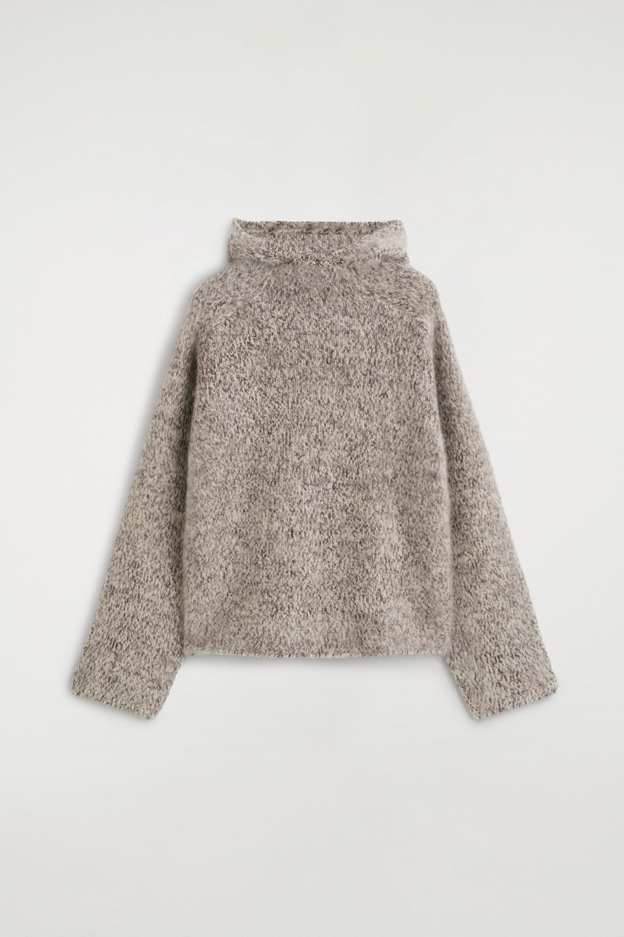 A chunky brushed-cashmere hoodie is shown from the back, featuring a relaxed silhouette with raglan sleeves and a high, folded hood. The garment is constructed from a textured, heathered grey and beige knit with a soft, brushed finish.