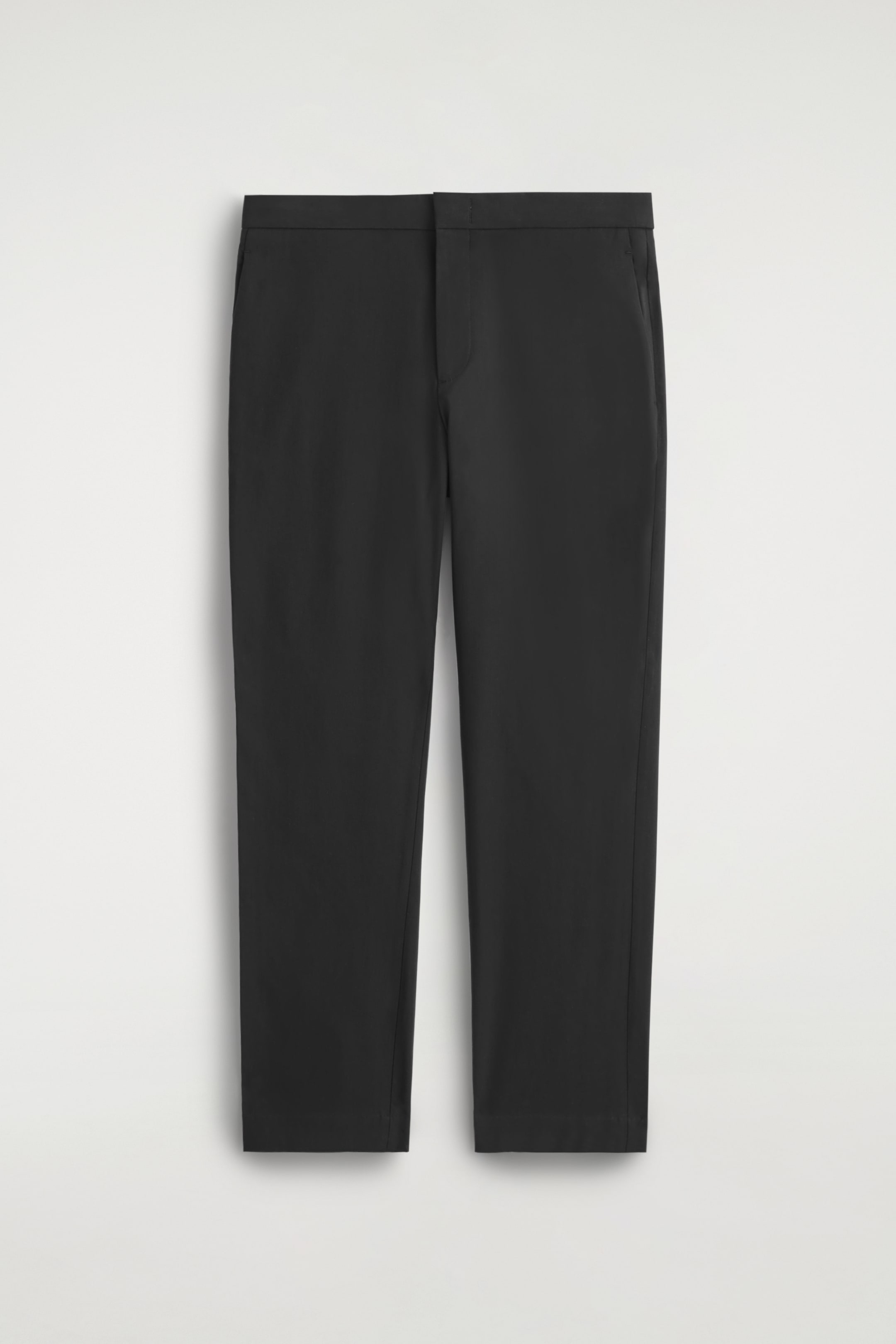 View larger image: Black slim-fit trousers are being presented from the front, featuring a flat waistband, angled side pockets, and straight legs with a smooth, clean hem.