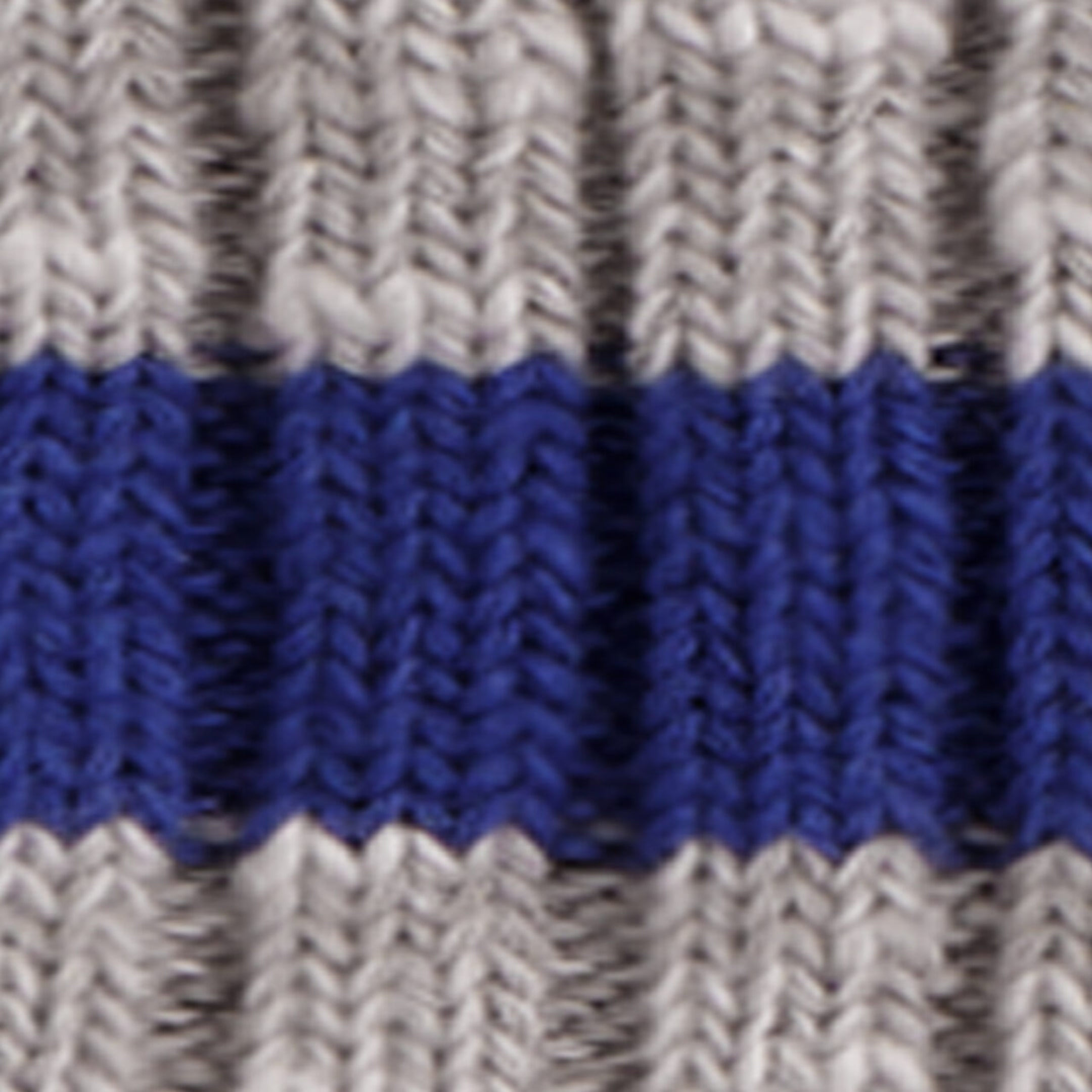 Le tissu en tricot côtelé présente un motif texturé avec des côtes grises verticales et une bande horizontale bleue unie qui traverse le centre.