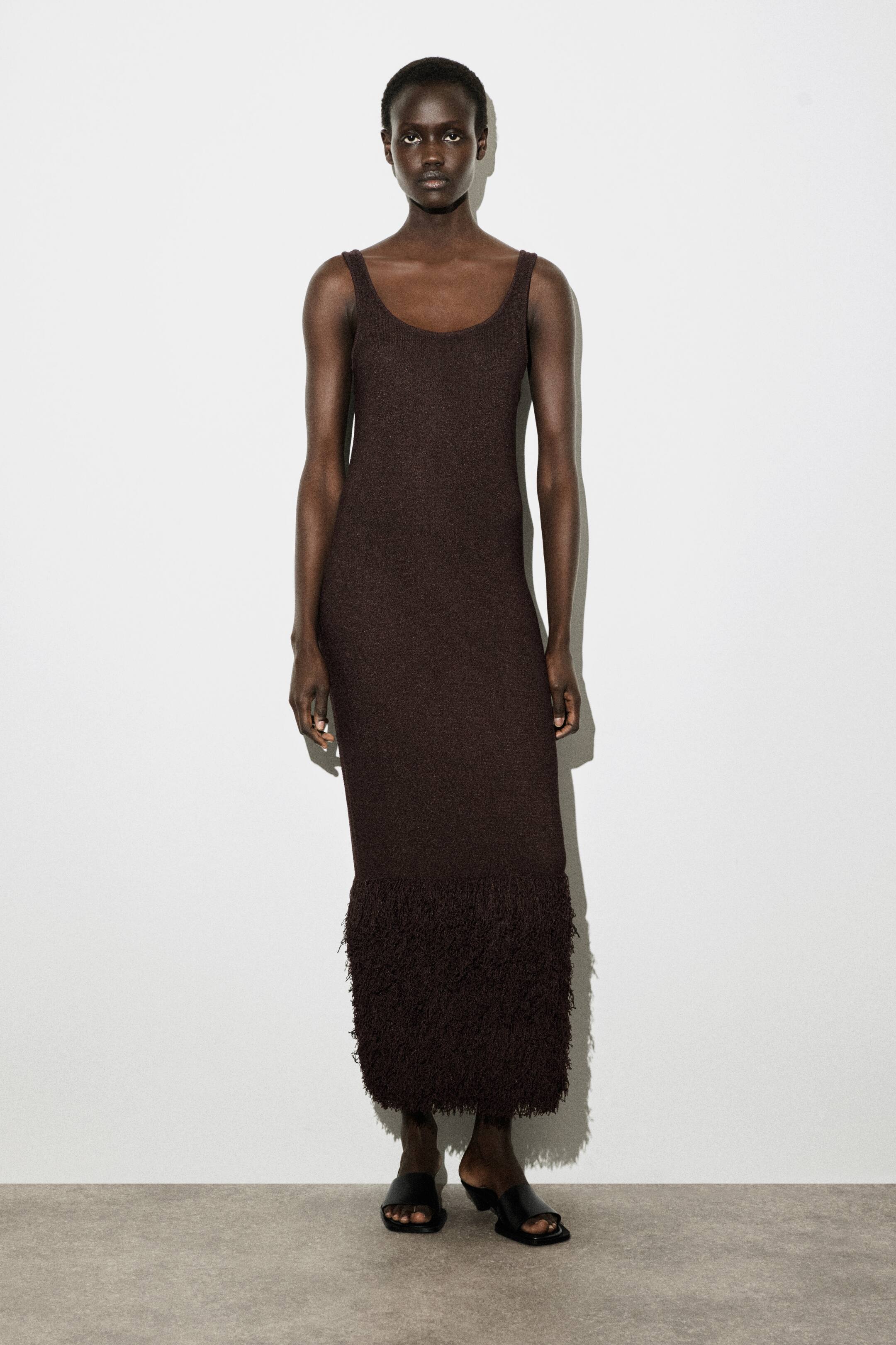 Agrandir l'image: La robe maxi sans manches de couleur marron foncé présente un décolleté rond et une silhouette ajustée qui s'étend jusqu'aux chevilles. Son ourlet est orné d'une frange contrastante et effilochée.