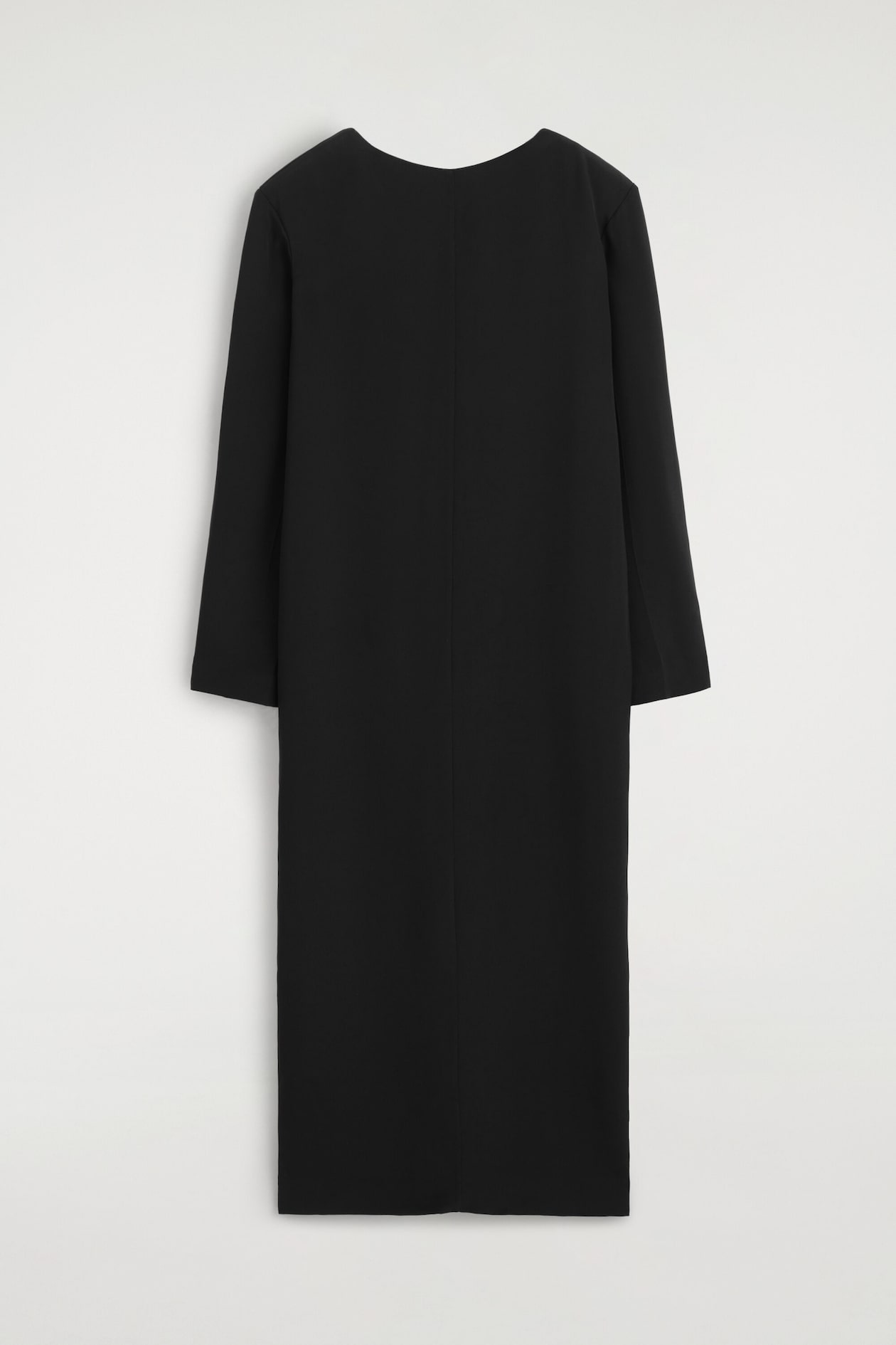 A black maxi dress is shown from the front, showcasing its crew neck, structured shoulders, and long sleeves. The dress features a straight, tailored silhouette with a clean vertical seam running down the centre.