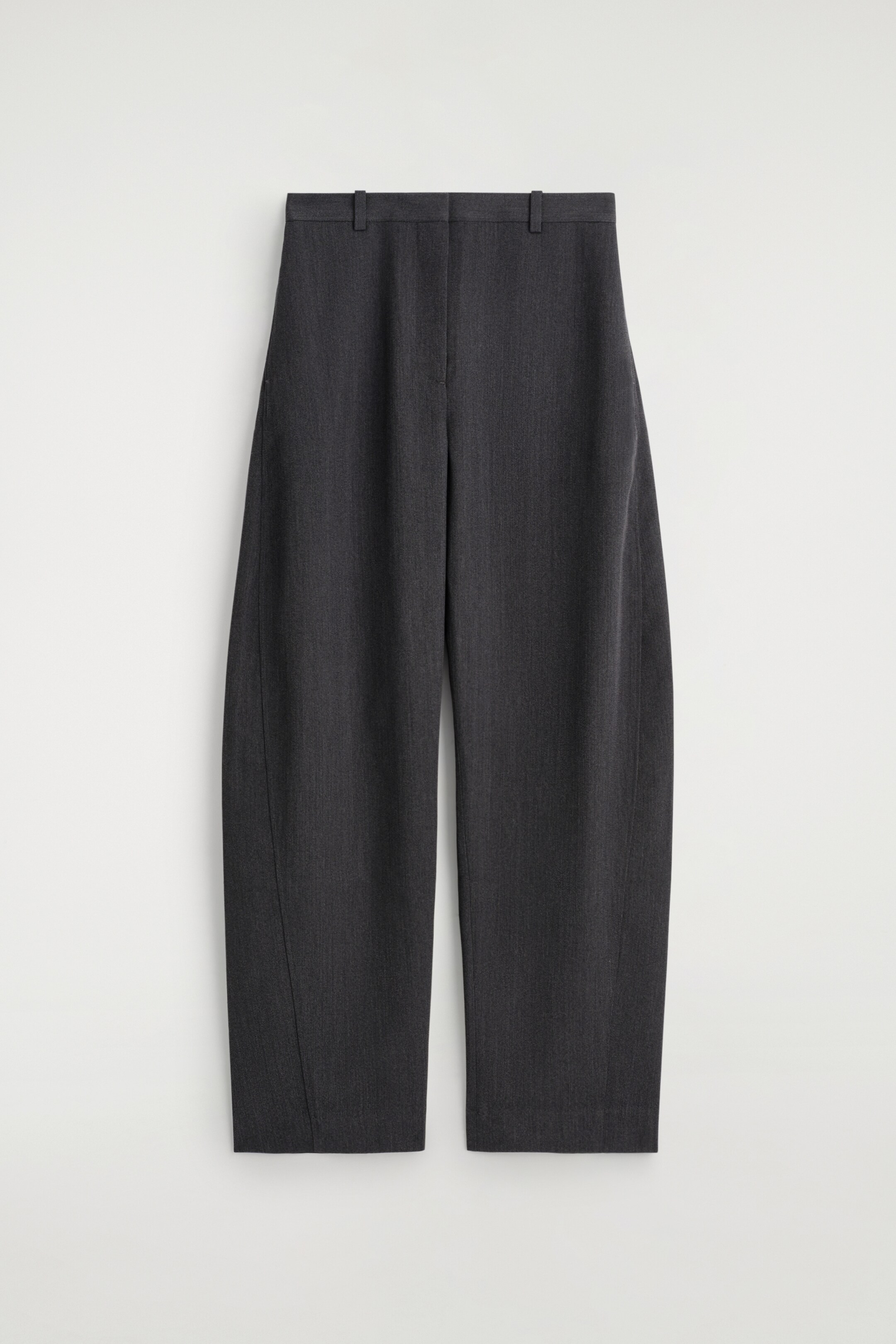 View larger image: A pair of charcoal barrel-leg trousers is presented from the front, featuring a sculptural silhouette with seams curving around each leg and belt loops at the waist.