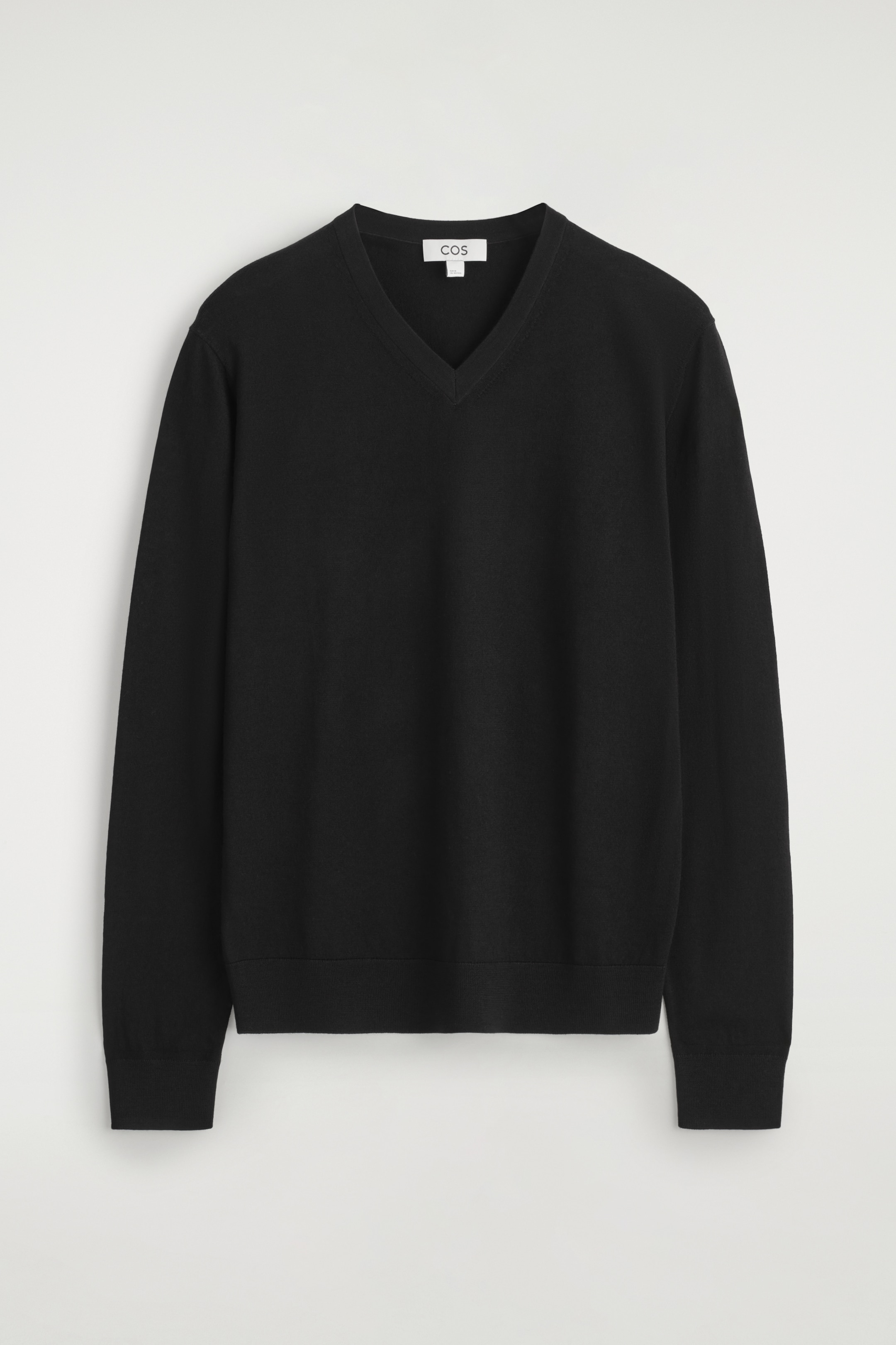 Visualizza immagine più grande: Un maglione nero in lana merino con scollo a V è esposto FRONTE, caratterizzato da maniche lunghe, orlo a coste e polsini a coste.
