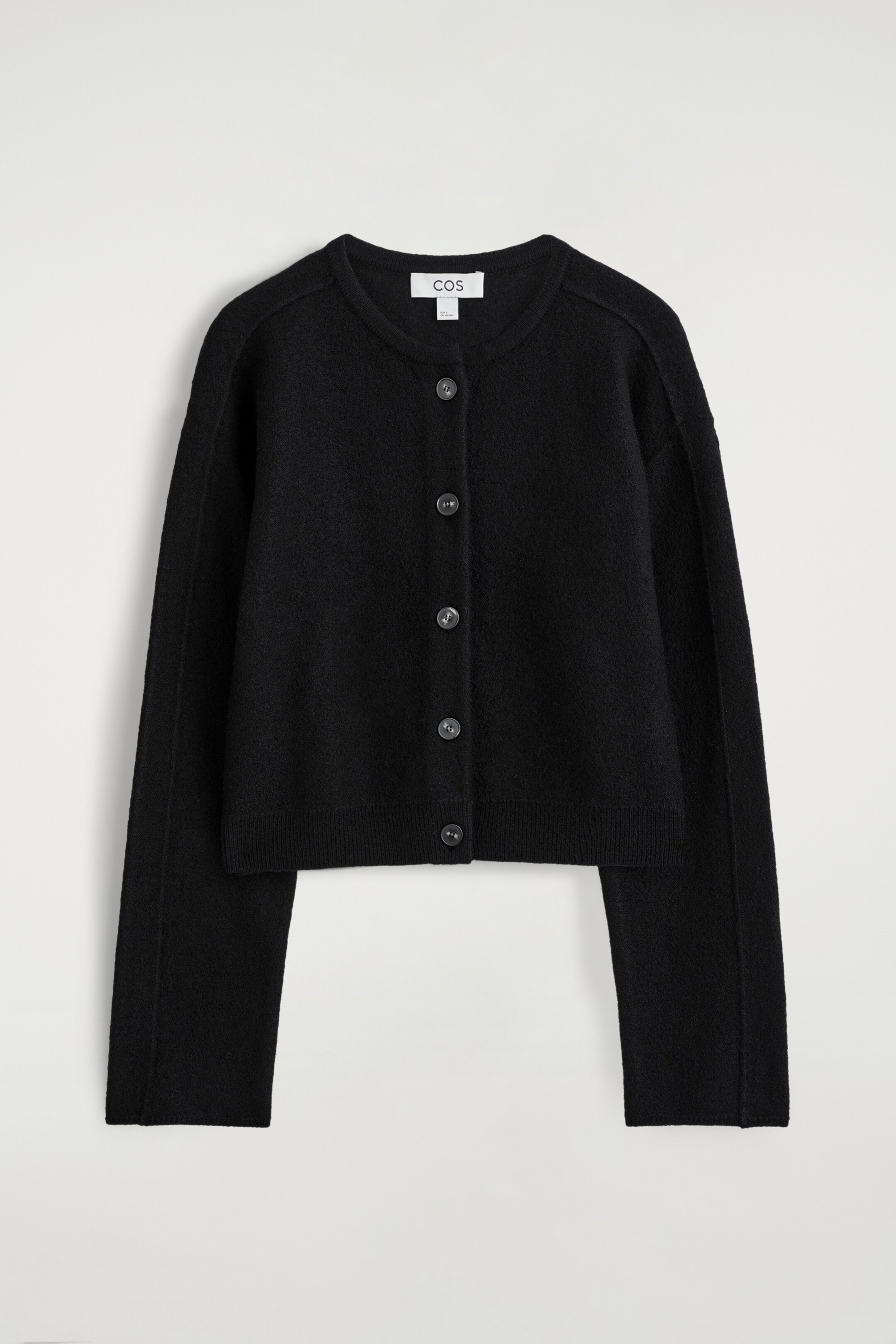 Agrandir l'image: Un cardigan noir à col rond est affiché à L'AVANT, avec une surface texturée et une fermeture intégrale par boutons, comprenant six boutons ronds et foncés. Il est conçu avec des manches longues et des coutures discrètes qui se chevauchent aux épaules, se terminant par un ourlet droit.