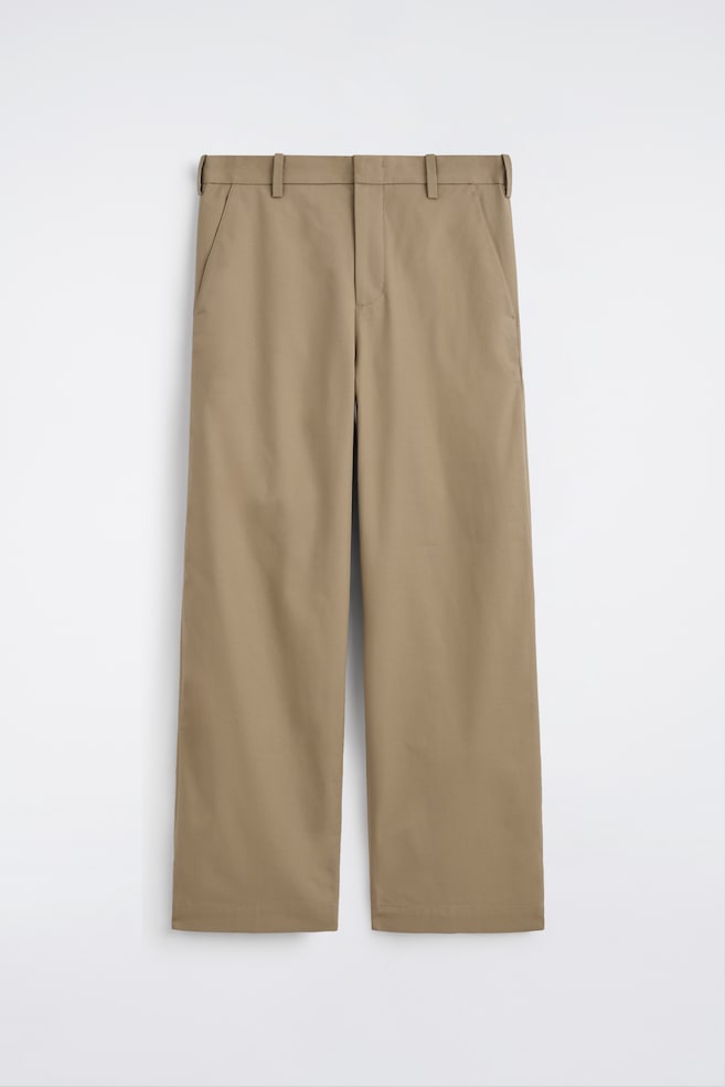 A pair of beige wide-leg chinos is presented at the front, featuring a tidy waistband with belt loops, a concealed front fastening, and two side pockets. - 1