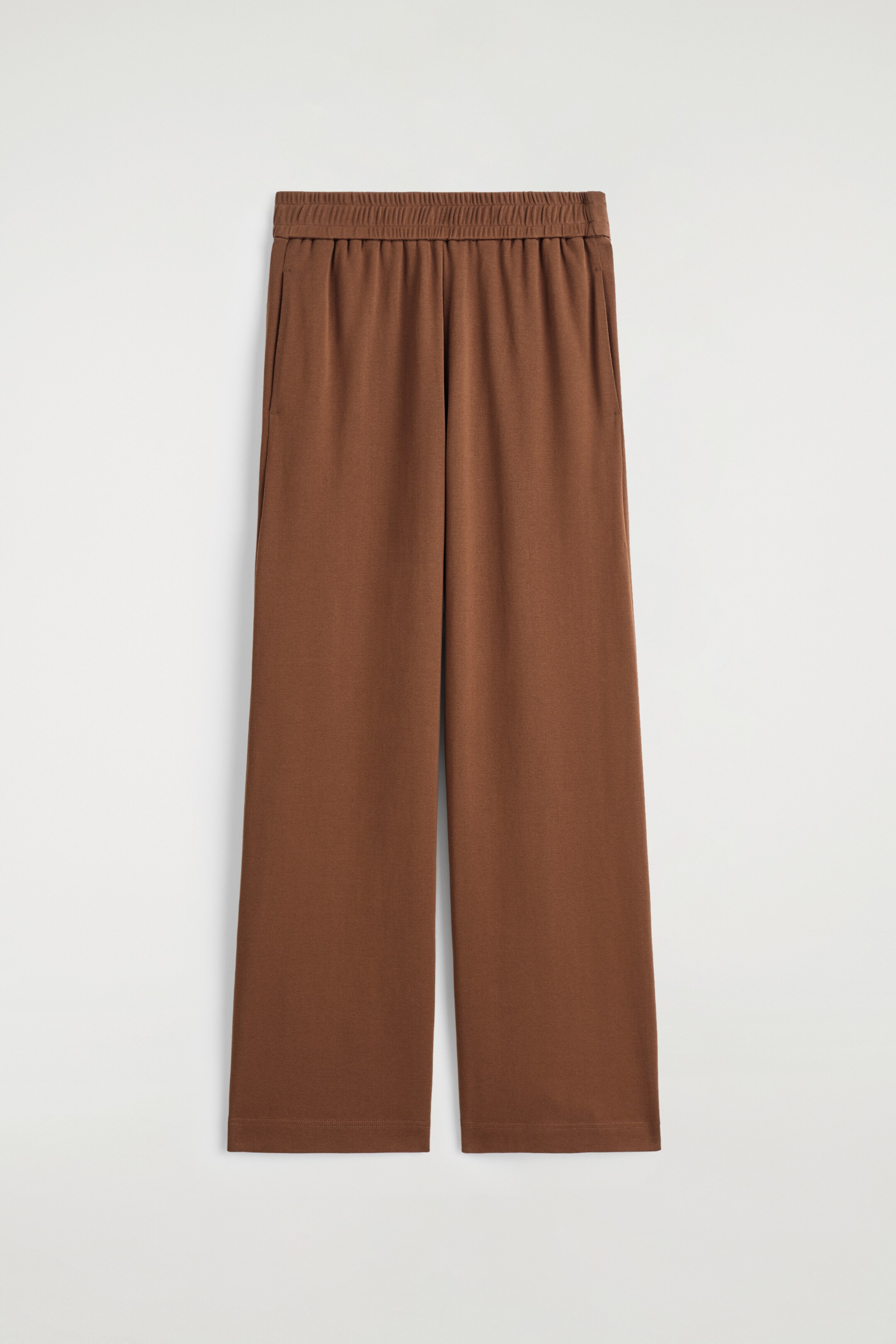 Agrandir l'image: Les joggeurs Fluid Jersey apparaissent en vue de face. Les joggeurs marron présentent une taille élastiquée, des poches latérales et une coupe fluide à jambes larges avec des ourlets droits.