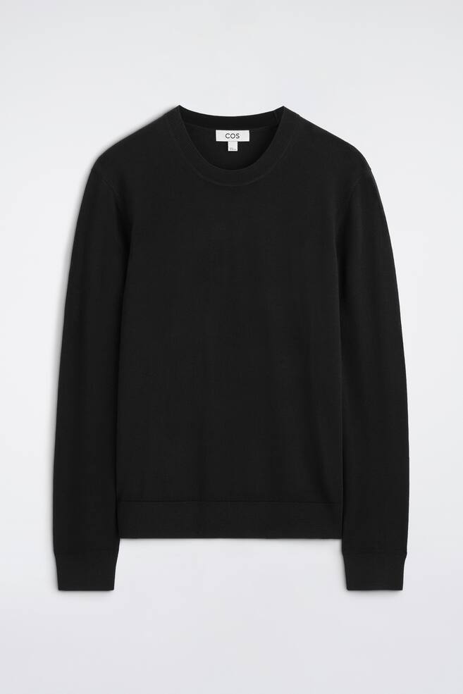 A black crew-neck jumper is facing forwards, featuring long sleeves with ribbed cuffs and a ribbed hem. - 1