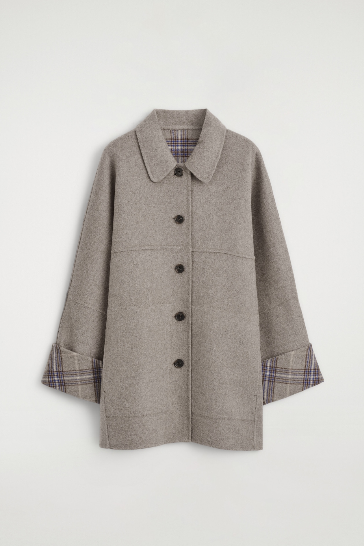 A front-facing view of a beige wool-blend coat shows a spread collar, a five-button front closure, and wide sleeves. The turned-up cuffs and inner collar display a contrasting blue and brown check pattern.