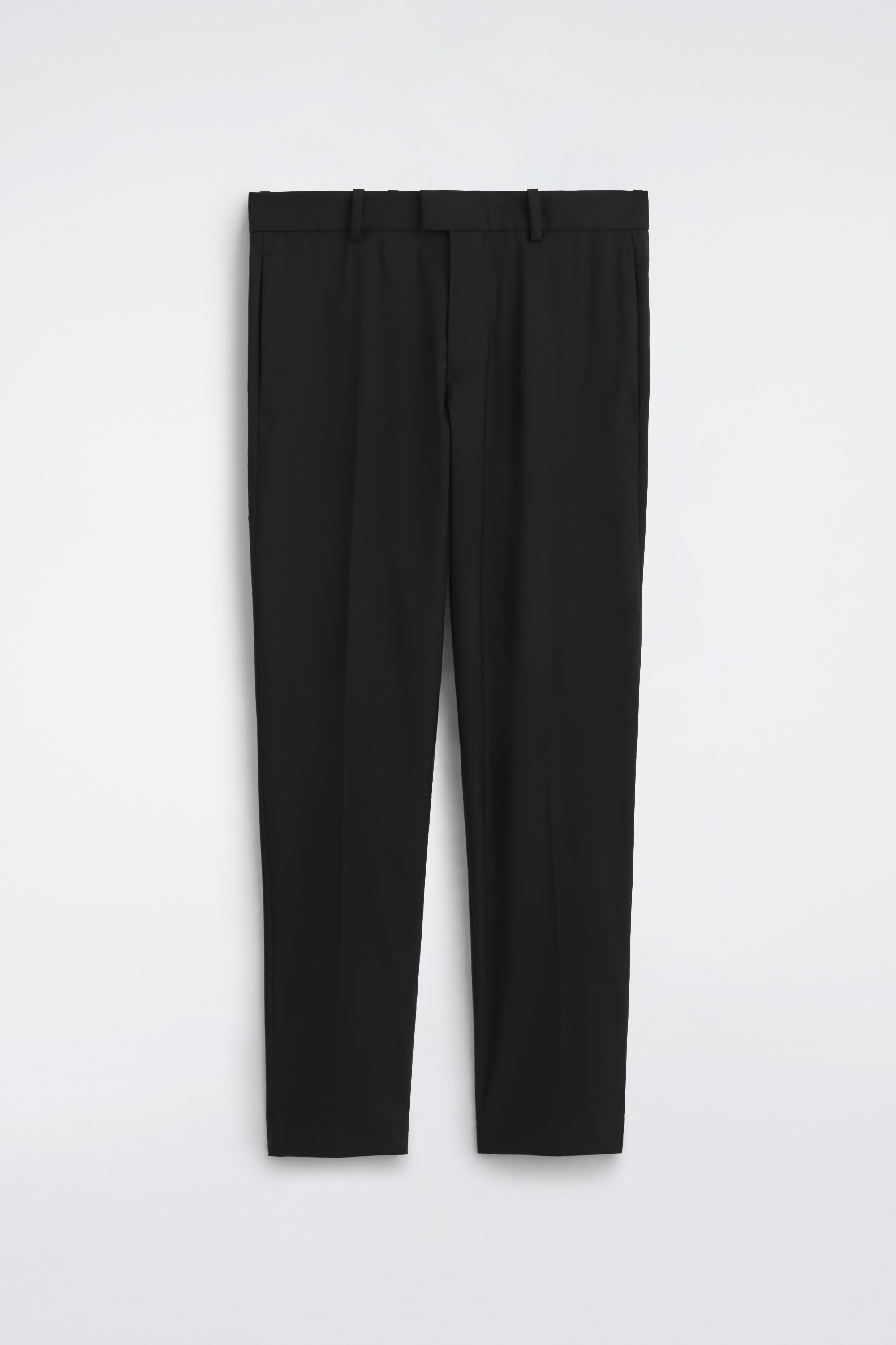 Questi pantaloni slim fit a gamba dritta in misto lana sono mostrati frontalmente e presentano un design sartoriale con pieghe stirate ben definite lungo ciascuna gamba. Una cintura in pelle nera con fibbia color argento Ã¨ infilata nei passanti, mentre un maglione nero in maglia Ã¨ parzialmente infilato nella vita.