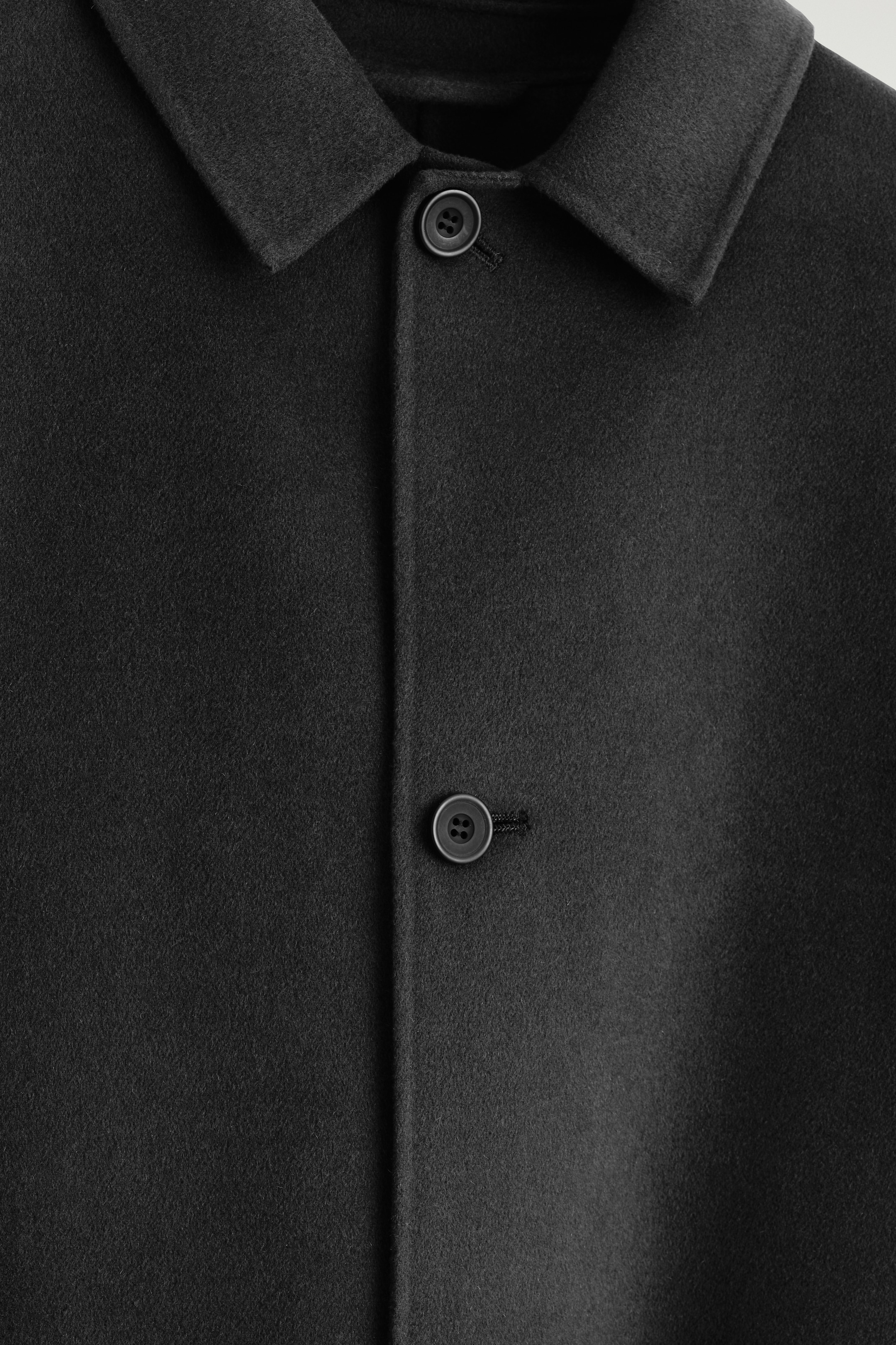 Visualizza immagine più grande: Un cappotto color espresso scuro mostra il suo FRONT, caratterizzato da un colletto a punta e una chiusura centrale con due bottoni scuri visibili. Il cappotto presenta una texture di tessuto liscia e densa.