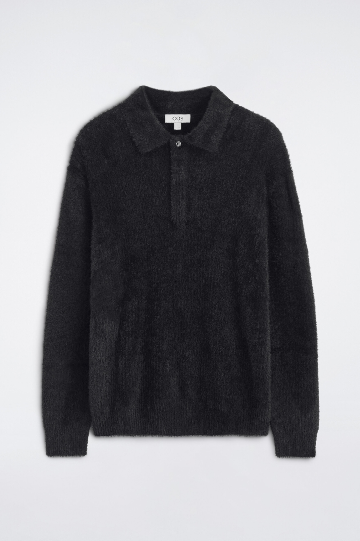 A long-sleeved knit polo shirt in black is shown from the front, featuring a soft, brushed texture. The shirt has a polo collar with a single-button placket, long sleeves, and ribbed cuffs and hem.