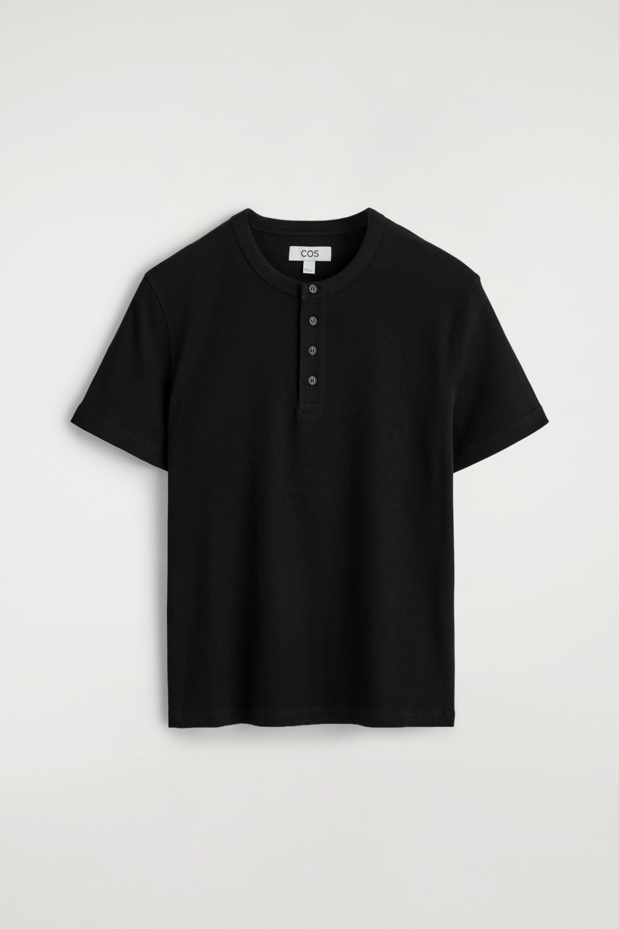 Agrandir l'image: Un T-shirt Henley noir se présente comme FRONT, avec une texture finement côtelée. Il présente une coupe ajustée avec des manches courtes et une patte de boutonnage à quatre boutons s'étendant depuis l'encolure ronde.