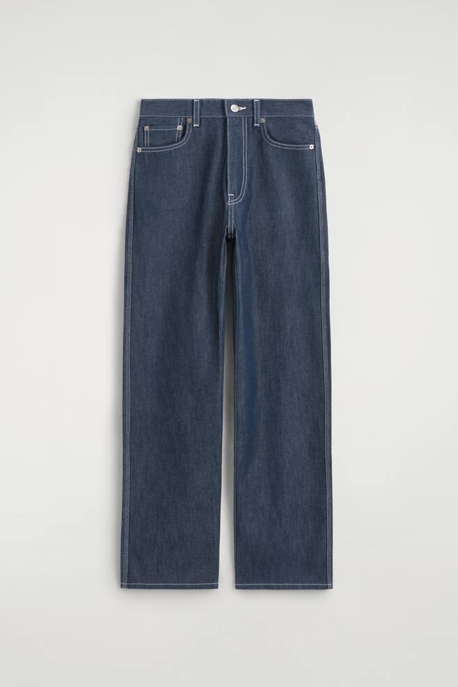 Die von vorne gezeigten CHORD Jeans mit offener, gerader Beinform und ZiernÃ¤hten prÃ¤sentieren eine dunkelblaue Raw-Denim-Konstruktion mit auffÃ¤lligen weiÃen KontrastnÃ¤hten, die Taschen, NÃ¤hte und Saum betonen. Die Jeans verfÃ¼gen Ã¼ber ein klassisches Five-Pocket-Design, einen Bund mit GÃ¼rtelschlaufen, einen Knopfverschluss und eine gerade Silhouette. - 1