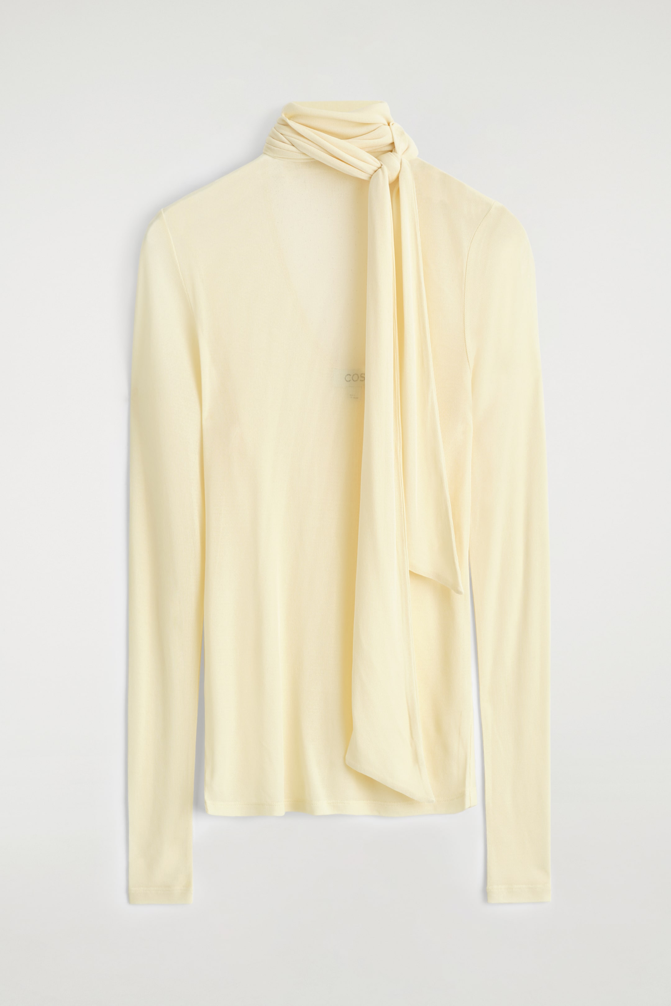 Agrandir l'image: Un haut à manches longues de couleur jaune clair est présenté de face, avec une coupe ajustée, un tissu lisse et léger, et une écharpe tonale intégrée enroulée et nouée autour du col montant, dont les extrémités tombent sur le devant.