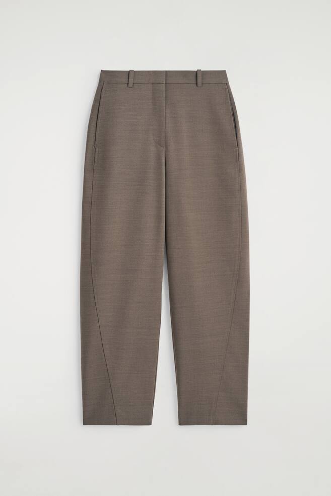 A pair of mole tone merino wool-twill trousers is shown as FRONT, featuring a barrel-leg shape with prominent forward-facing seams that are accentuating a rounded silhouette. The trousers are designed with a flat waistband, belt loops, and side seam pockets. - 1