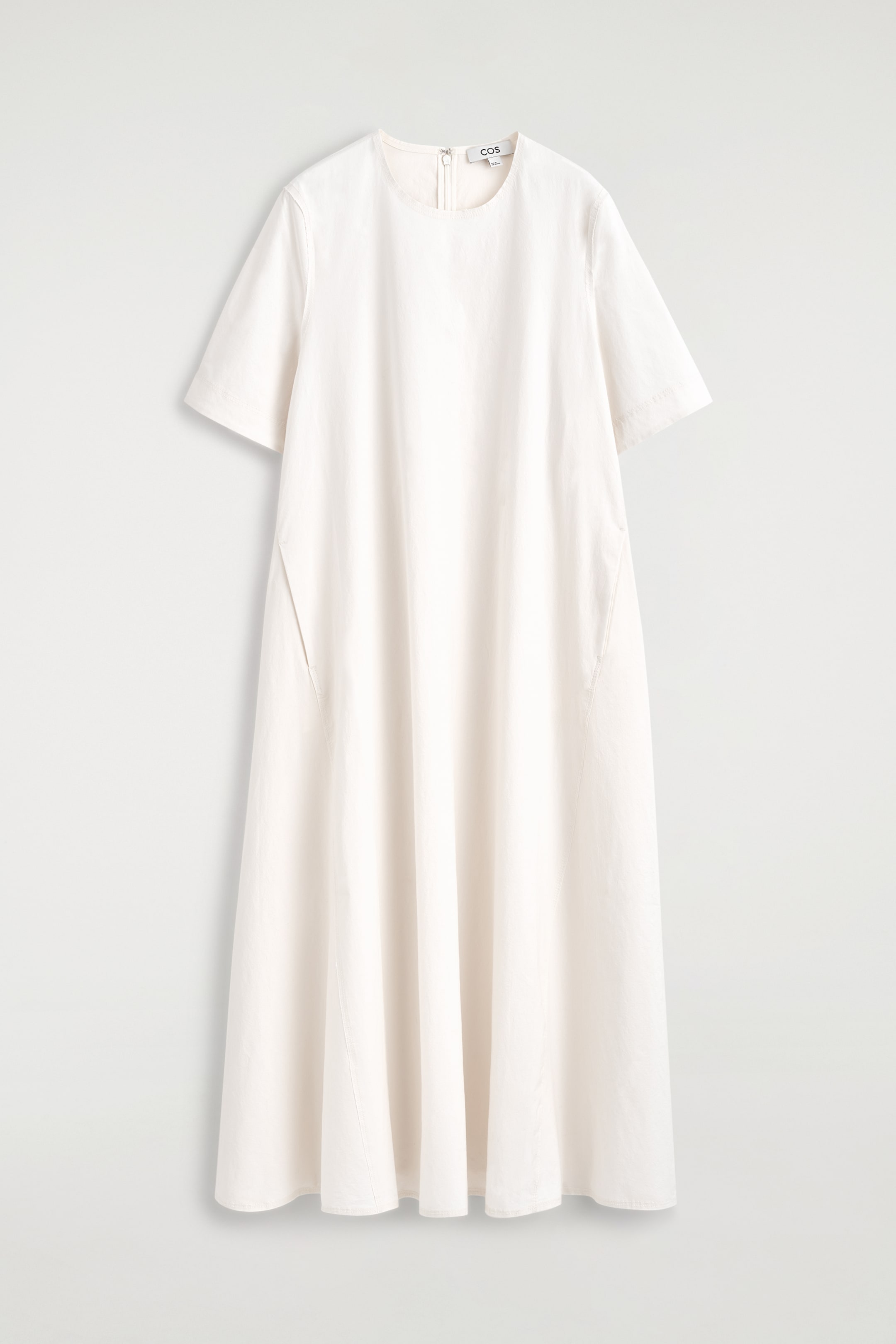 Ver imagen más grande: Un vestido midi blanco roto se presenta de frente, con un cuello redondo, mangas cortas y anchas, y una silueta suelta en línea A. Presenta bolsillos en las costuras laterales y un cierre de cremallera visible en la parte trasera del cuello.