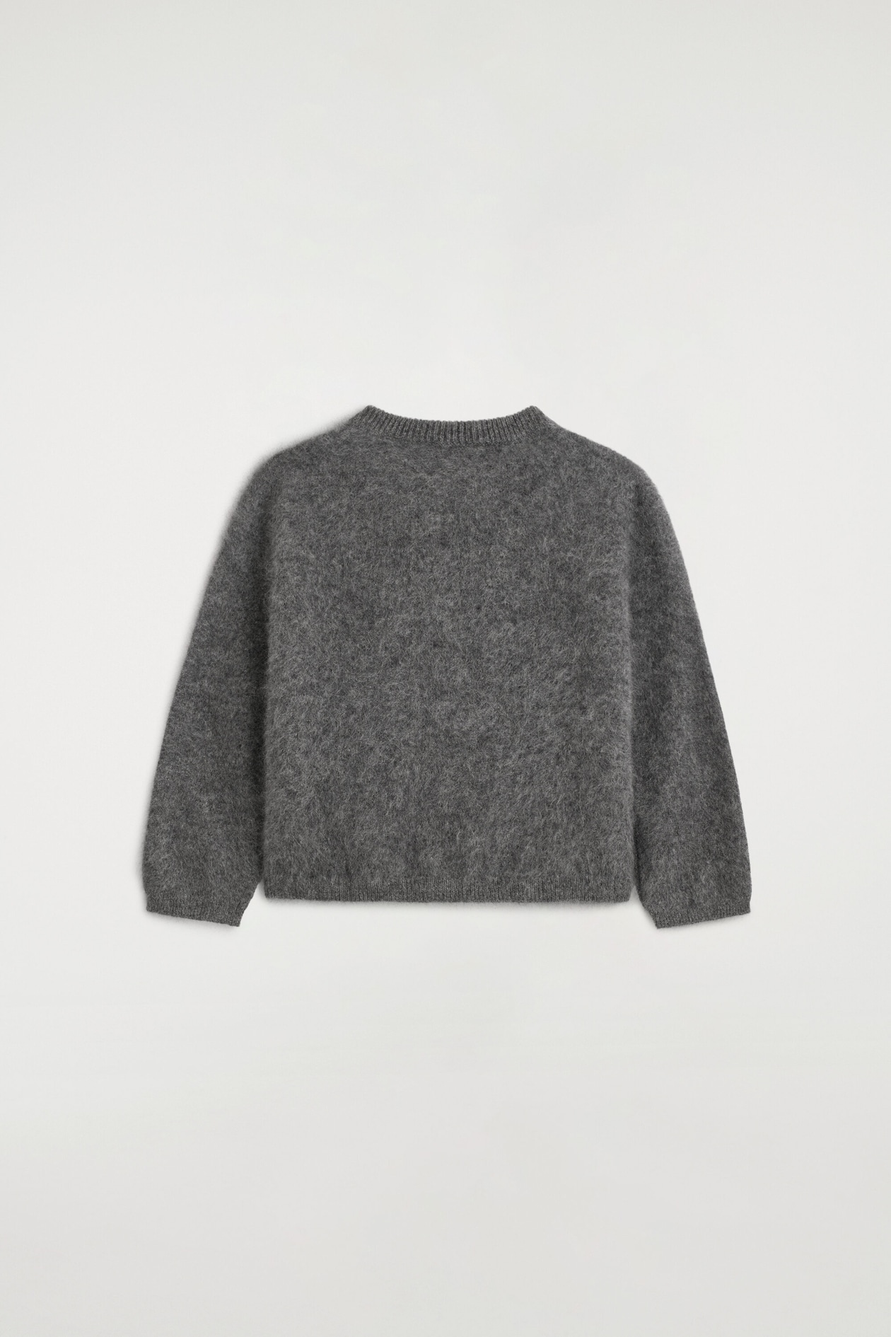 A kids’ brushed pure cashmere cardigan is shown from the back, showcasing its soft, grey brushed texture. The design features long sleeves with ribbed cuffs, a ribbed collar, and a ribbed hem.