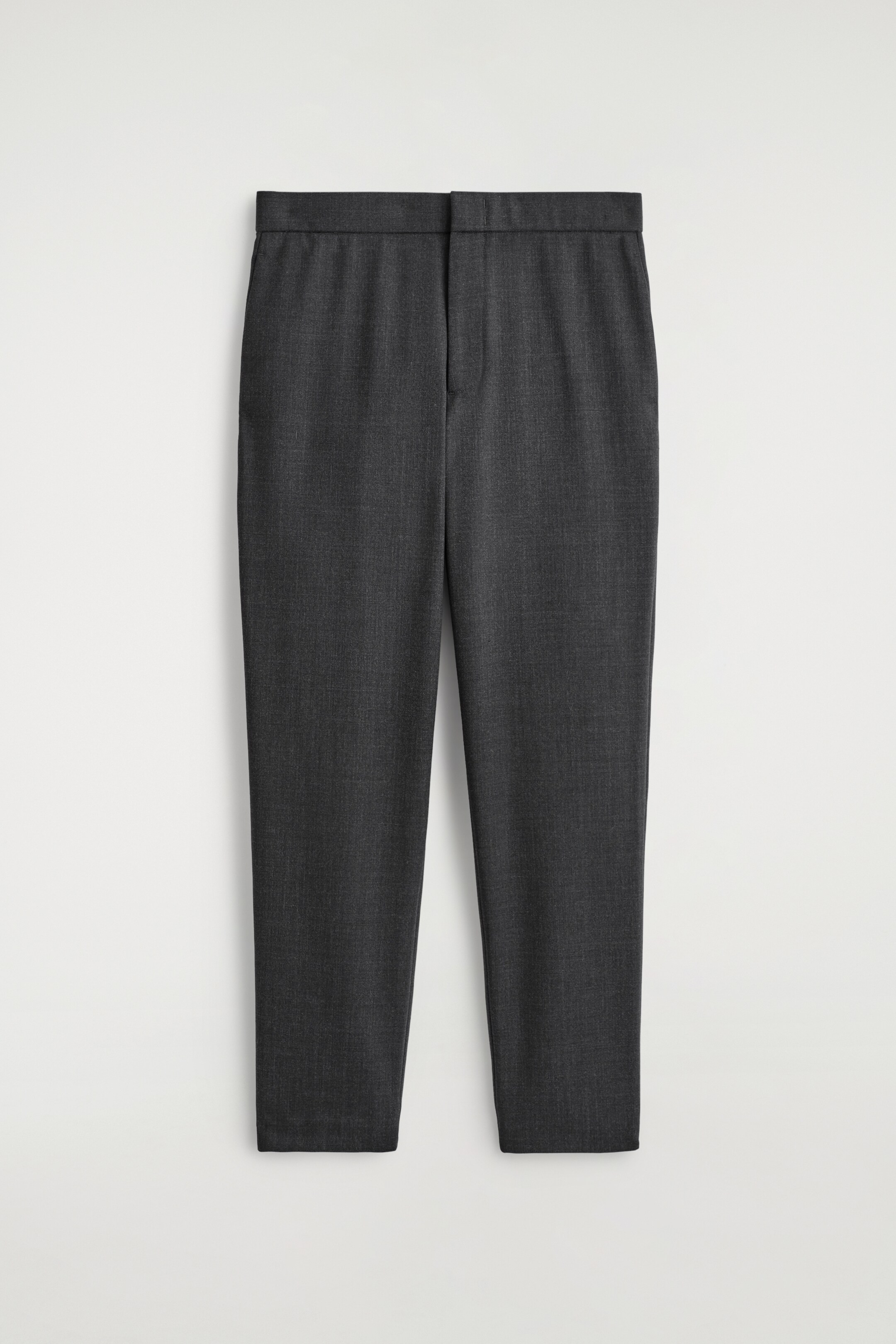 Agrandir l'image: Une paire de pantalons skinny-fit gris foncé est exposée de face. Ils présentent une ceinture plate avec une couture de fermeture visible au centre et un tissu subtilement et finement texturé.
