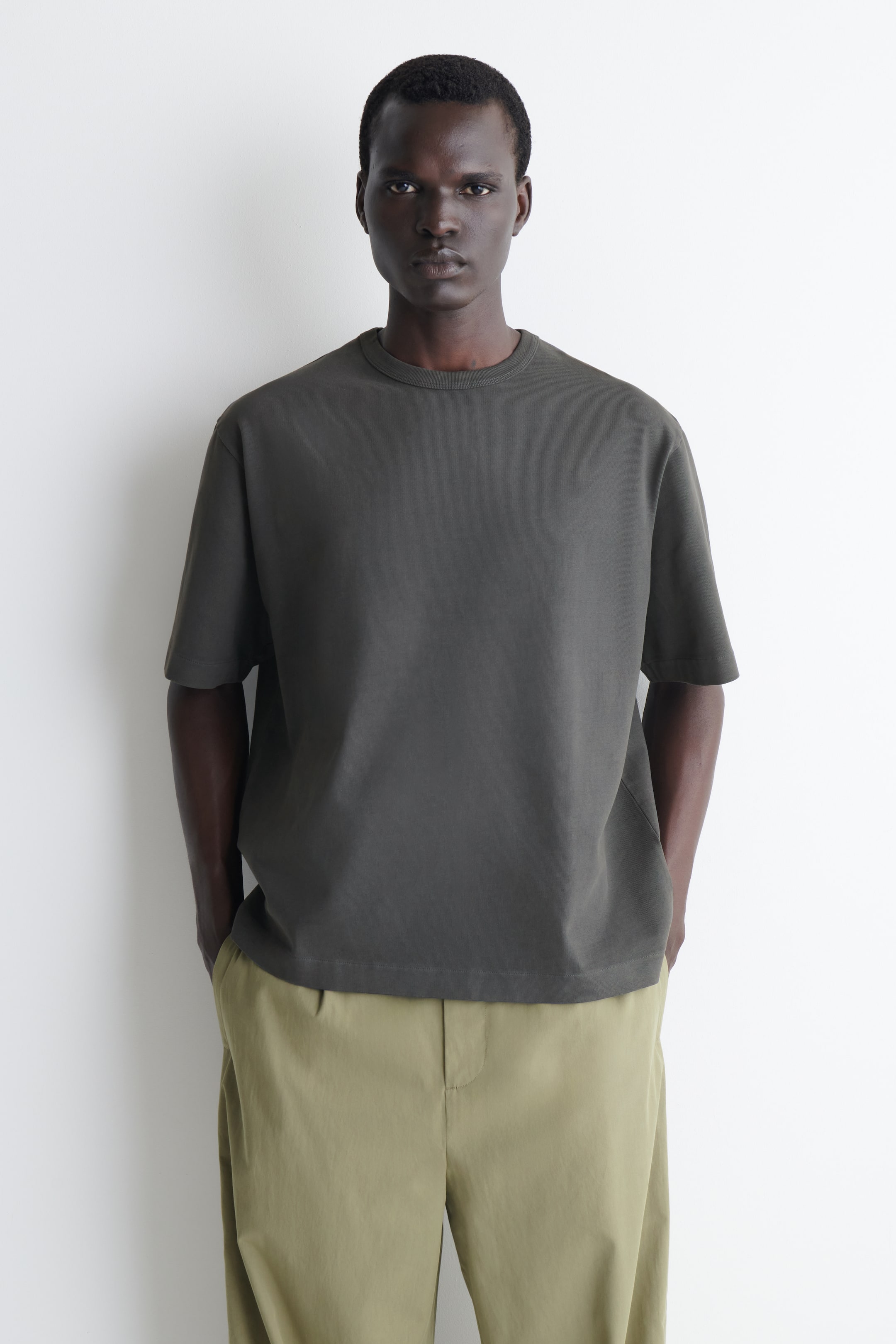 Agrandir l'image: Un t-shirt vert olive foncé avec un col rond et des manches courtes, présentant une coupe décontractée et un ourlet droit tout en étant orienté vers l'avant.