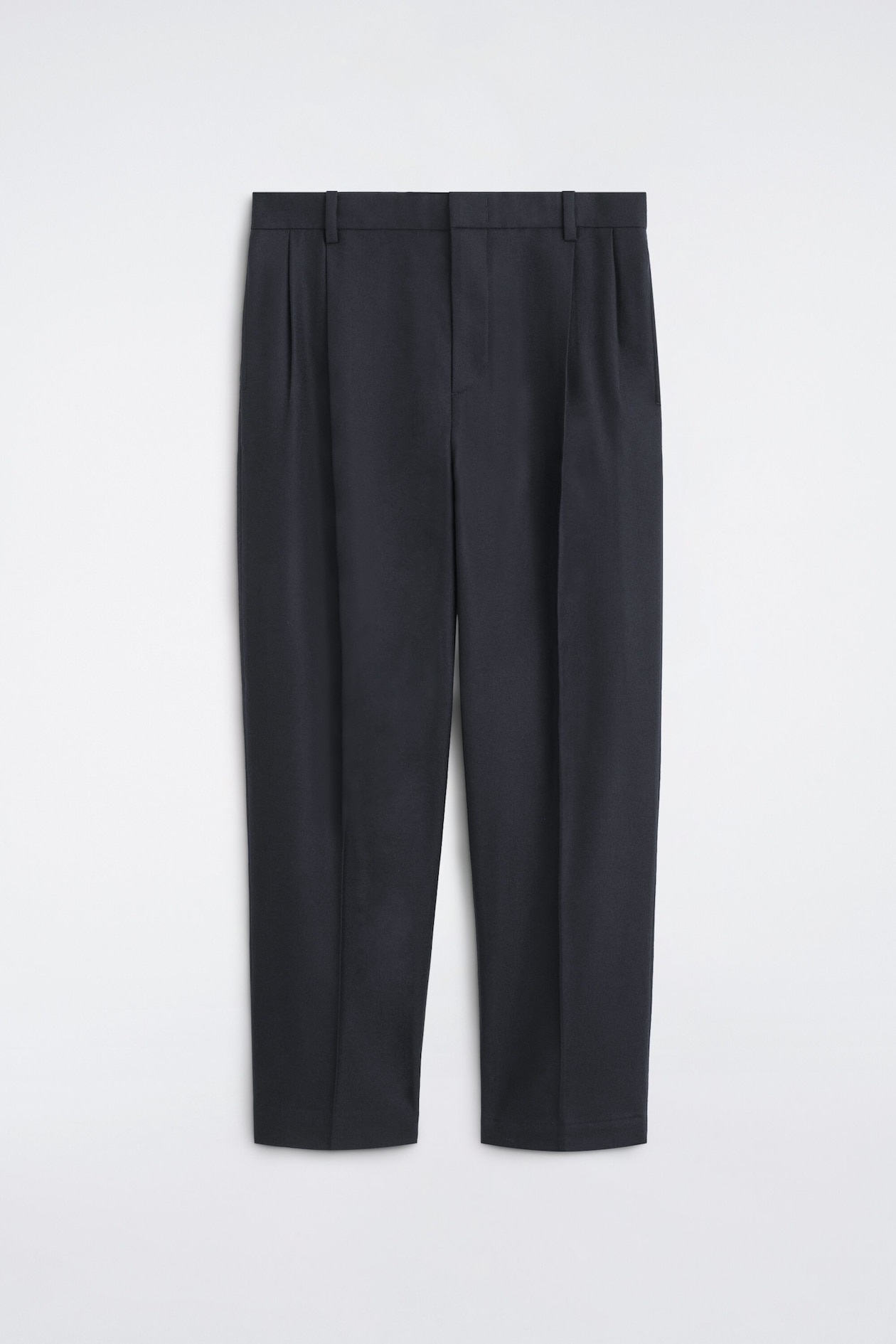 Eine dunkelmarineblaue Hose wird von vorn gezeigt und verfügt über einen strukturierten Bund mit Gürtelschlaufen, Bundfalten vorne und scharfe Bügelfalten, die mittig an jedem Hosenbein verlaufen.