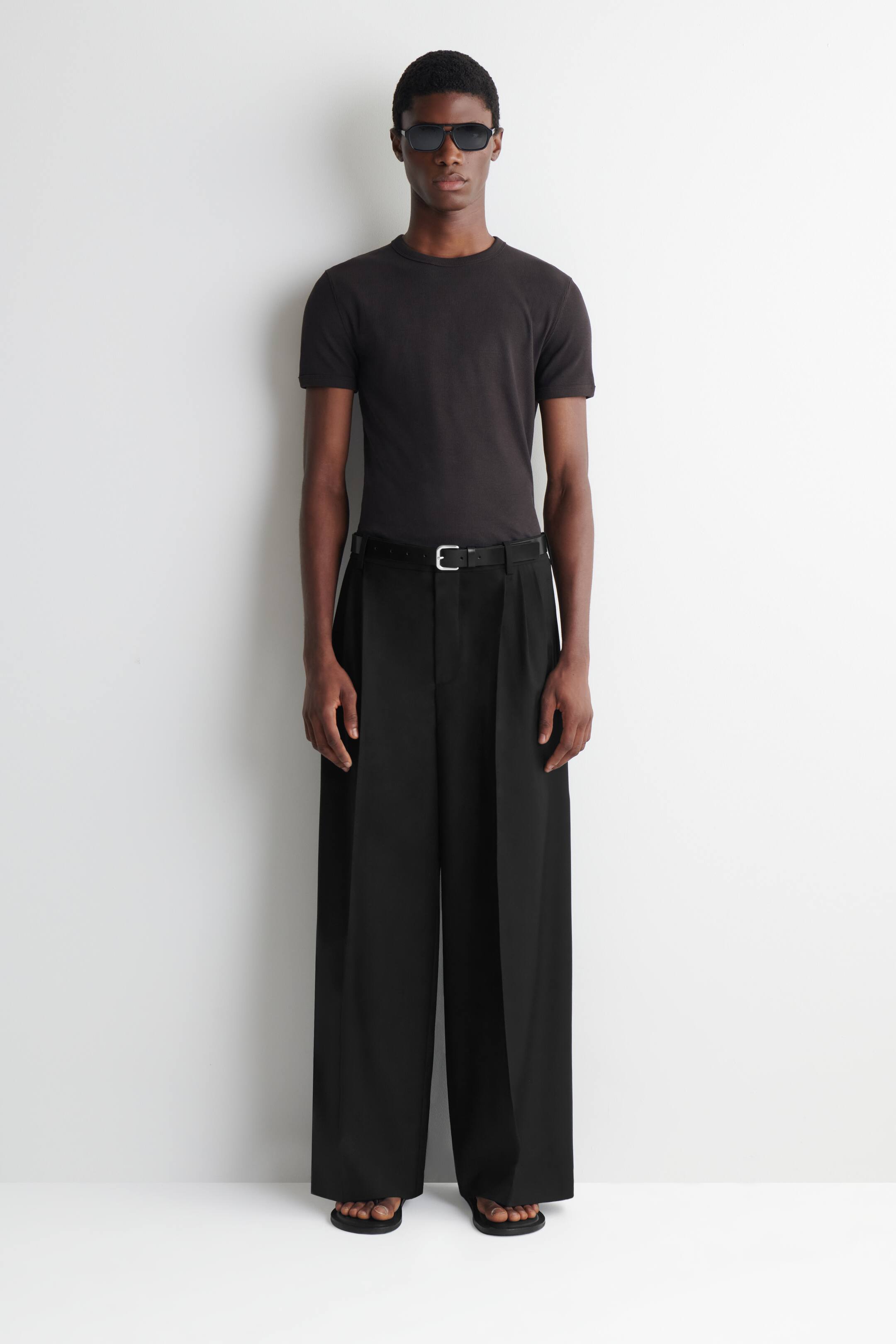 Grotere afbeelding bekijken: Broek met plooien, ontspannen pasvorm en wijd uitlopende pijpen - ZWART - HEREN | H&M BE 1
