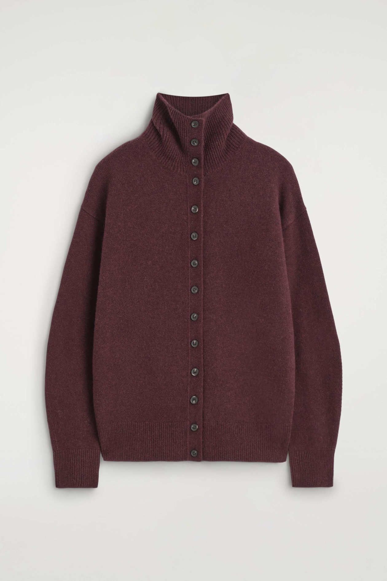 A burgundy knit cardigan is shown facing front, featuring a high, ribbed funnel neckline and a full-length button fastening. The design features dropped shoulders, long sleeves with ribbed cuffs, and a matching ribbed hem.