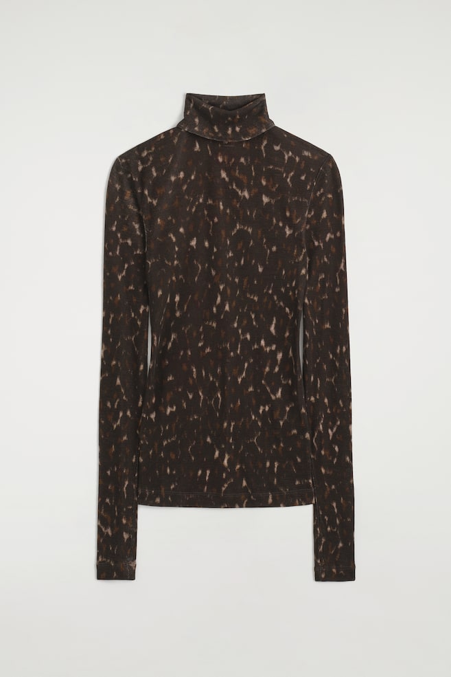 Este top de gola alta em lã merino está virado para a frente, apresentando um padrão abstrato salpicado por toda a peça em tons de castanho-escuro e bege. O top de manga comprida exibe uma gola alta dobrada e uma bainha direita. - 1