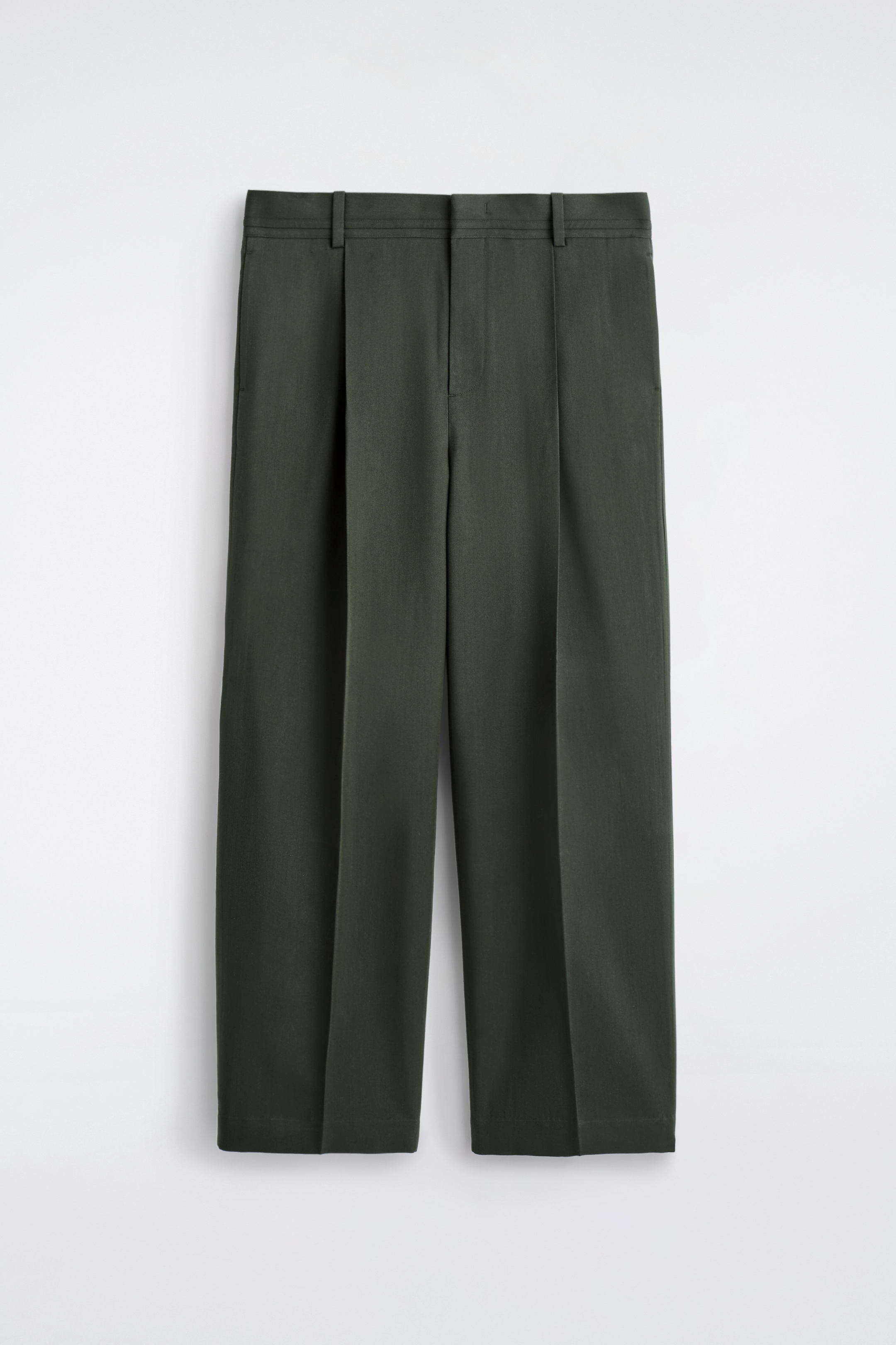 Ingrandisci l'immagine: I pantaloni a gamba larga verde scuro sono appesi, presentando la parte anteriore, con una vestibilità rilassata, passanti per cintura, pieghe in vita e dettagli con cuciture al centro di ciascuna gamba.