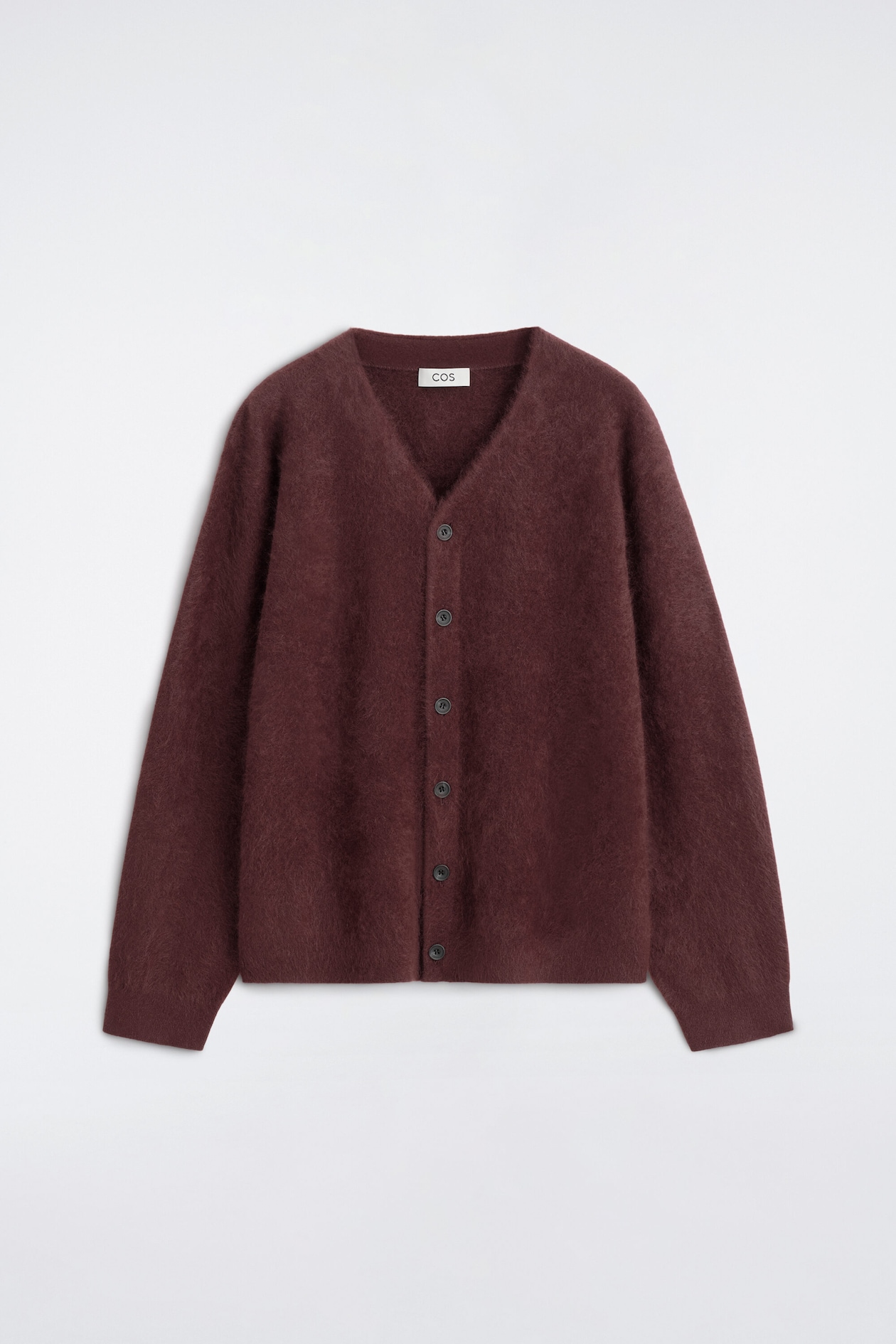 The brushed-cashmere V-neck cardigan is facing front, showcasing its soft, fuzzy texture in a deep burgundy hue. It features a classic V-neckline, a front button fastening, and ribbed detailing on the cuffs and hem.