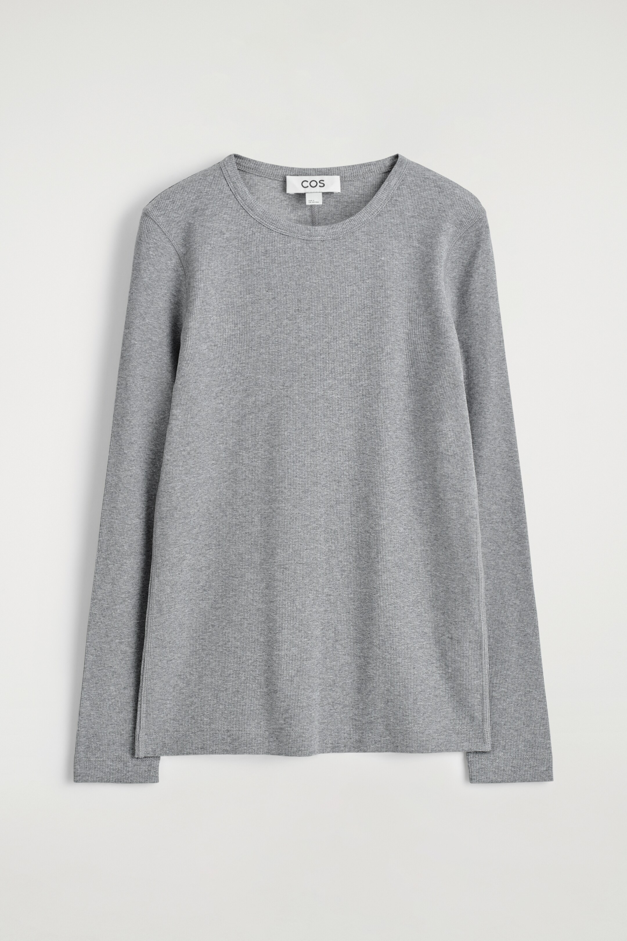 Ver imagen más grande: Un top de manga larga gris se presenta de frente. Cuenta con una textura acanalada en toda su extensión, un cuello redondo y pequeñas aberturas en los dobladillos laterales.