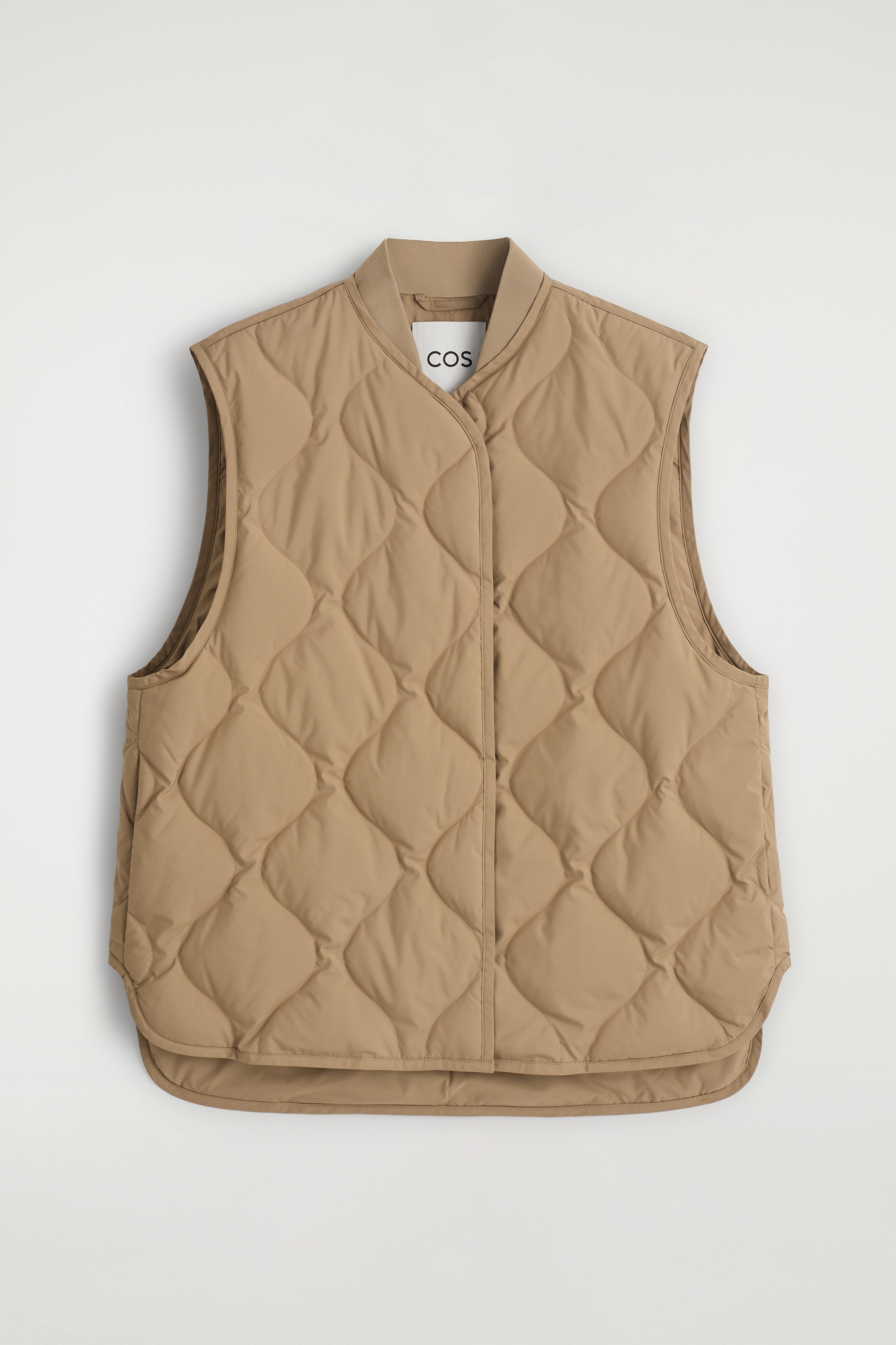 View larger image: A caramel-colored, quilted gilet is being presented FRONT, featuring a ribbed stand collar and a front placket. It is designed with an oversized fit and a rounded hem.
