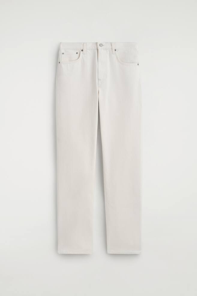 Een paar off-white jeans met rechte pijpen worden FRONT gepresenteerd, en reiken tot volledige lengte. Ze zijn voorzien van een knoop- en ritssluiting in de taille, twee voorzakken met metalen klinknagels en tonale stiksels. - 1
