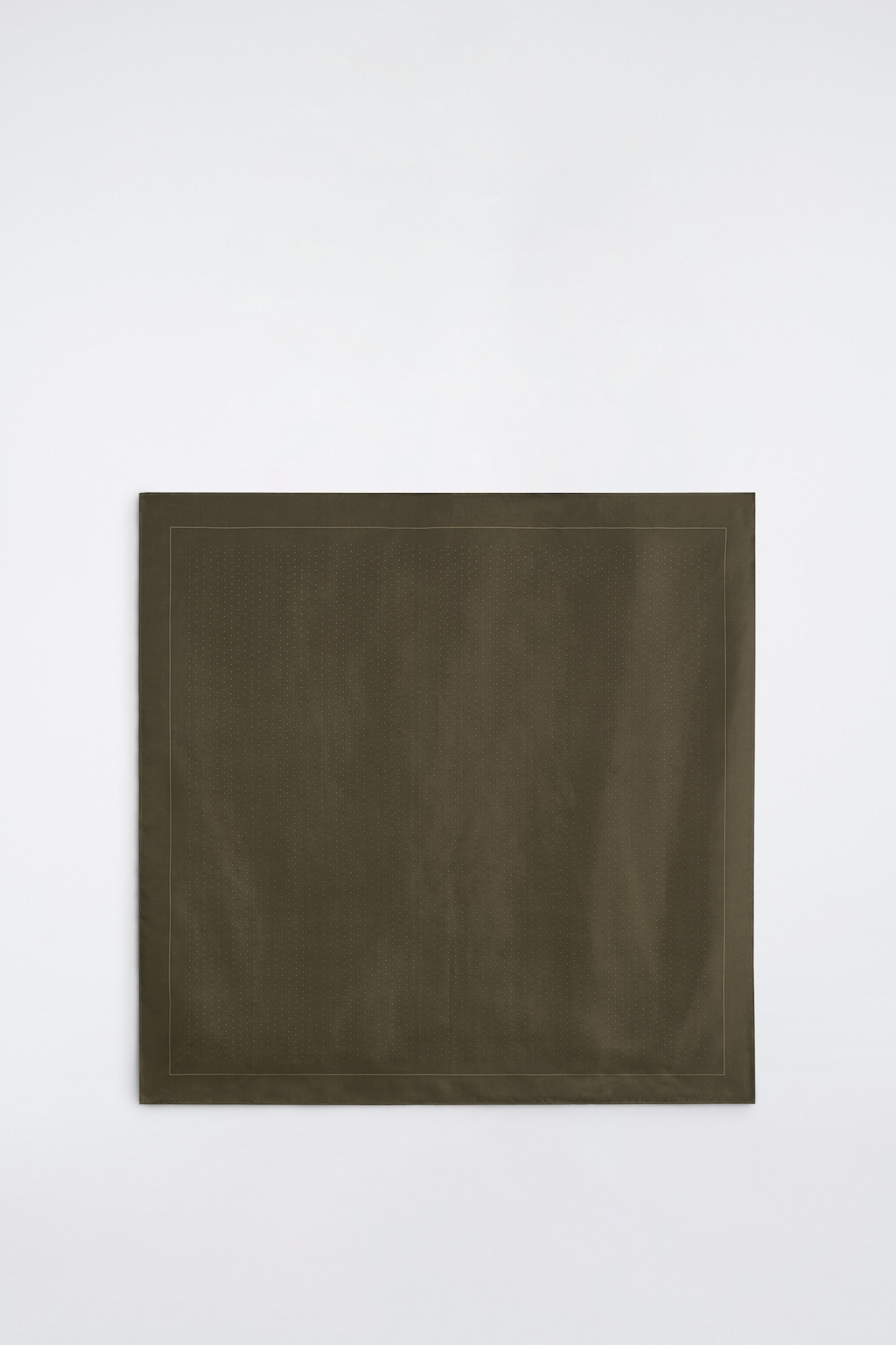 A polka-dot silk pocket square in dark olive green is laid flat in a front view, showcasing its smooth texture and square shape. It features a subtle, fine dotted pattern across the center area, framed by a thin border line and a solid outer hem.