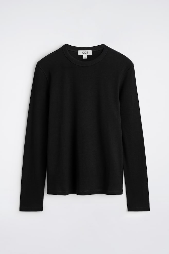 Un tricou negru cu mâneci lungi este prezentat frontal, având o textură fină cu nervuri pe toată suprafața corpului și a mânecilor. Are un guler rotund și un tiv drept, evidențiind o croială slim. - 1