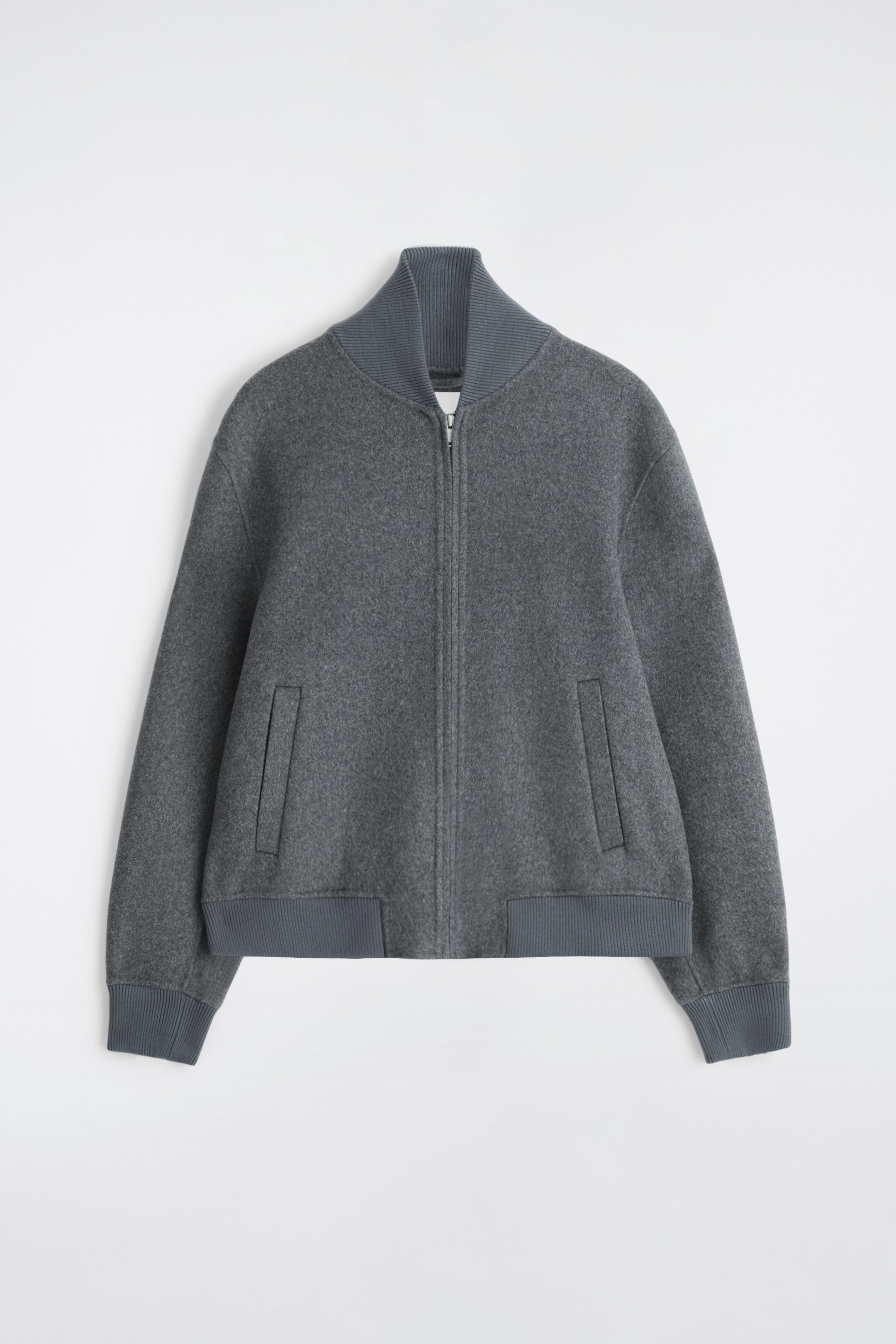 View larger image: A grey bomber jacket is displayed FRONT, featuring a textured fabric, a relaxed fit, a standing ribbed collar, a central front zip closure, two angled jetted pockets, ribbed cuffs, and a ribbed hem.