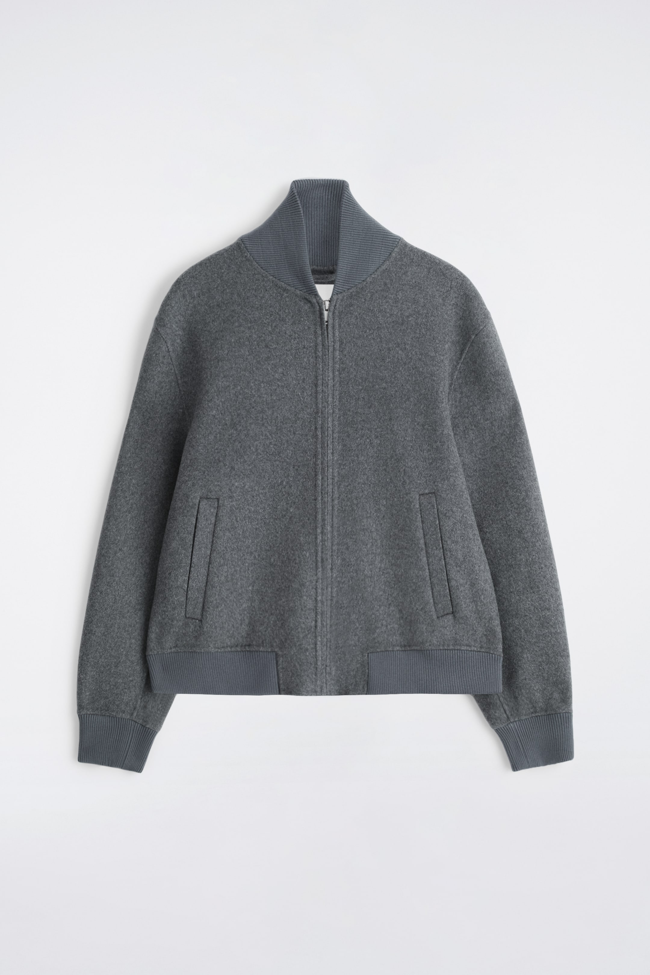 Ver imagen más grande: Una chaqueta bomber gris se muestra de FRENTE, con un tejido texturizado, un corte holgado, un cuello acanalado levantado, un cierre con cremallera central en la parte delantera, dos bolsillos inclinados de vivos, puños acanalados y un dobladillo acanalado.