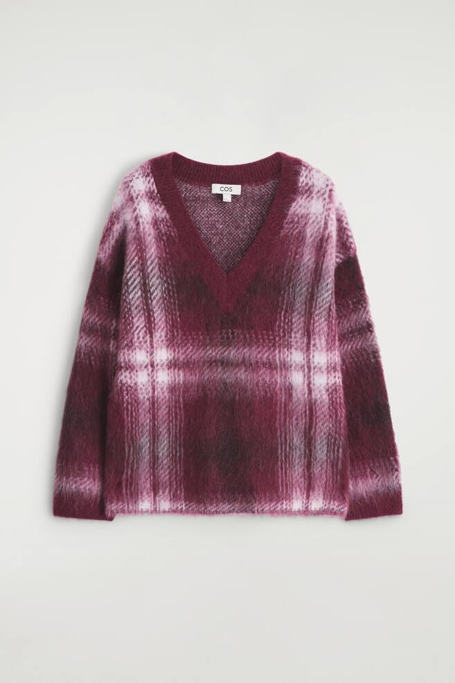 Una vista frontal de un suéter de punto cepillado con cuello en V, que presenta un ribete acanalado en el cuello en V y el dobladillo, y un patrón de cuadros difuminados en diferentes tonos de burdeos, magenta y blanco roto, está extendido. - 1