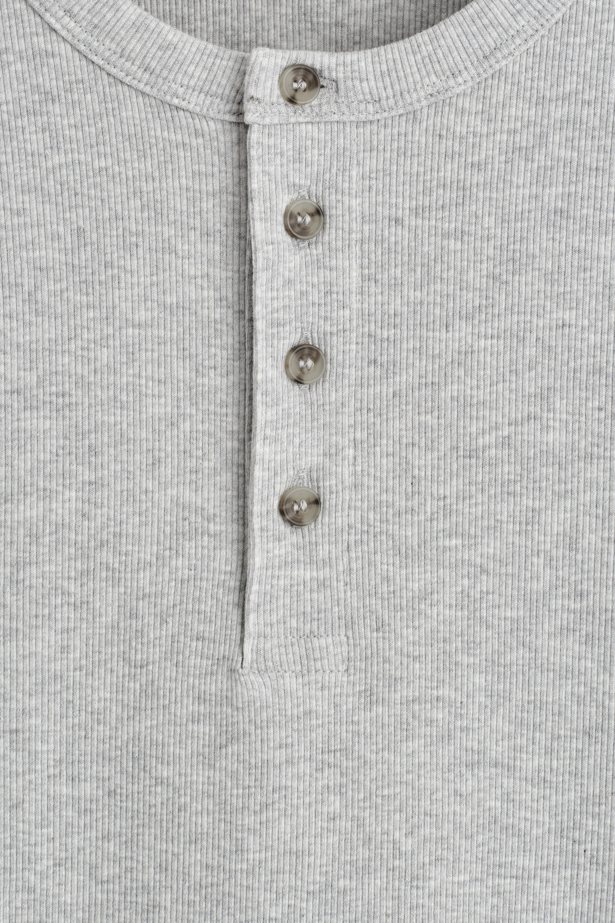 Agrandir l'image: Un t-shirt Henley gris est montré de face, avec une texture finement côtelée et une patte de boutonnage à quatre boutons gris.