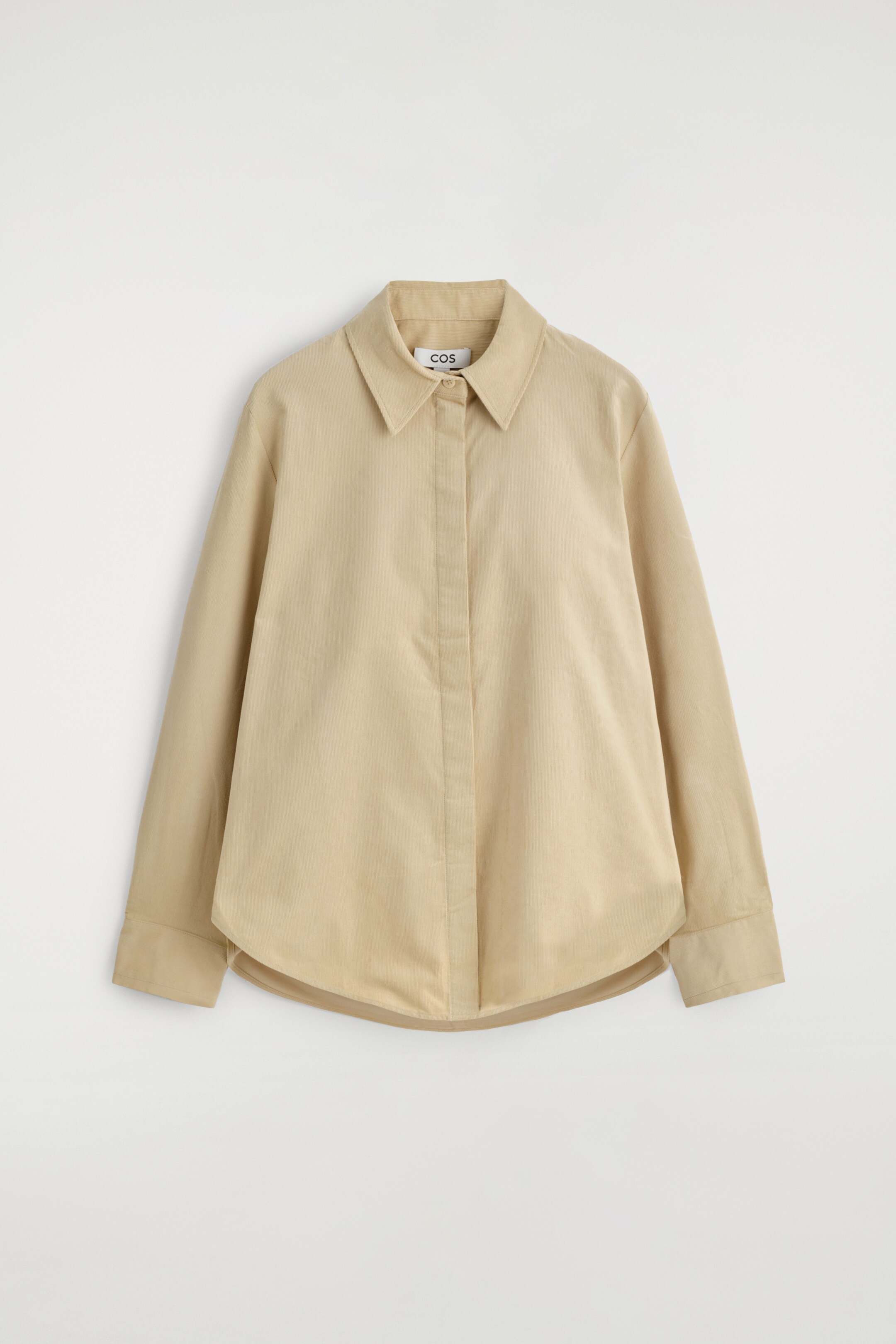 Agrandir l'image: Une chemise en velours côtelé beige est présentée de face, affichant une coupe classique, un col pointu, une patte de boutonnage dissimulée, des manches longues et un ourlet arrondi.