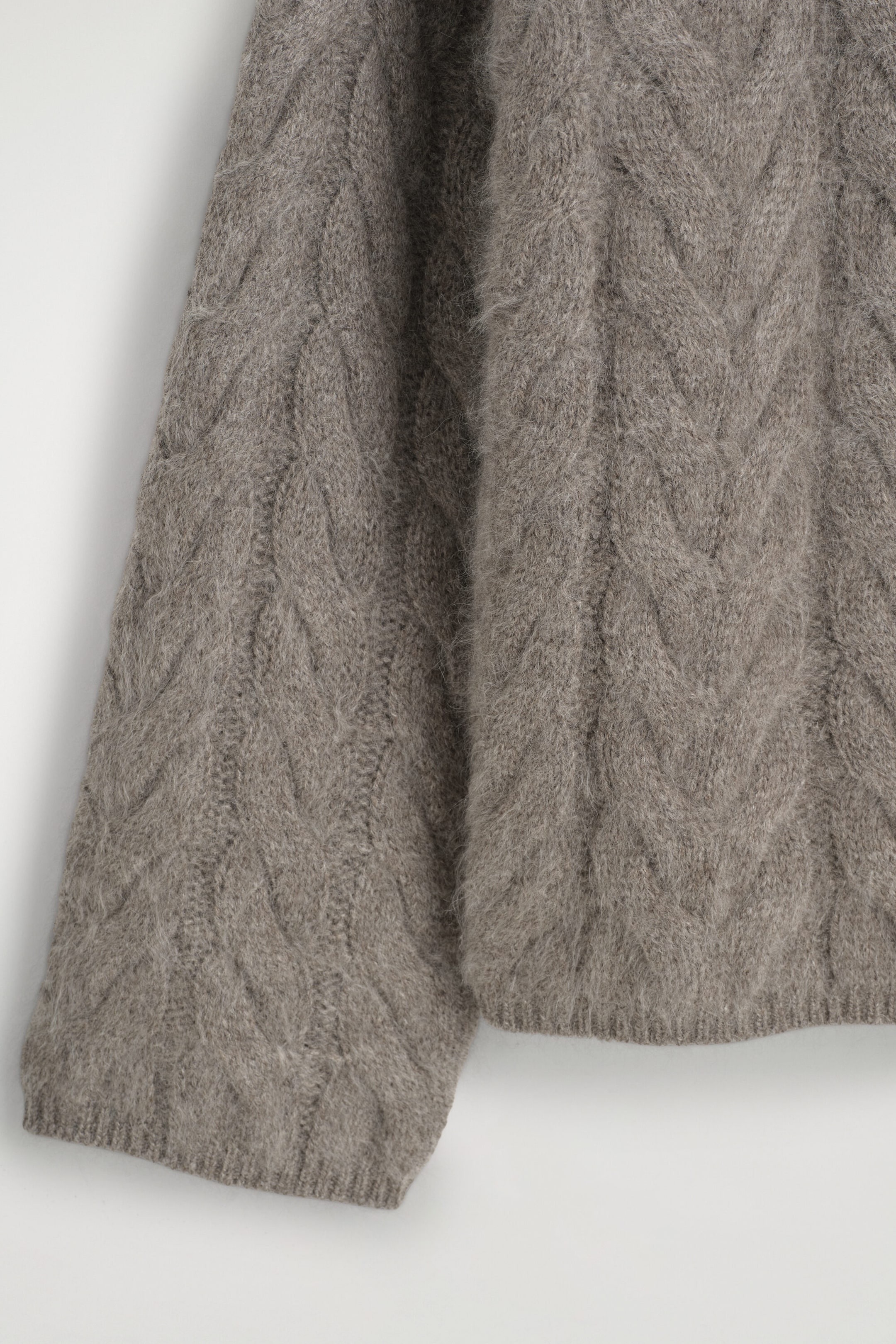 Le pull à col cheminée en cachemire brossé à torsades met en valeur, en gros plan de face, son motif à torsades épais et texturé ainsi que sa finition douce et duveteuse. Le vêtement présente un ourlet côtelé et un revers de manche côtelé assorti dans une teinte gris-brun neutre. Le pull à col cheminée en cachemire brossé à torsades met en valeur, en gros plan de face, son motif à torsades épais et texturé ainsi que sa finition douce et duveteuse. Le vêtement présente un ourlet côtelé et un revers de manche côtelé assorti dans une teinte gris-brun neutre.