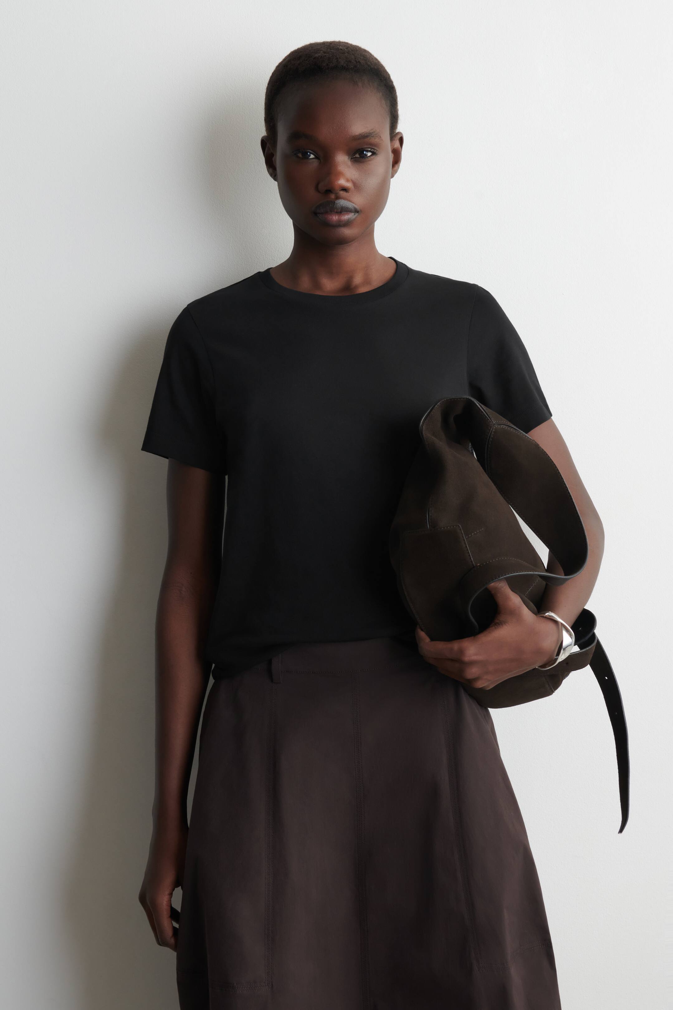 Agrandir l'image: Un t-shirt noir à manches courtes avec un col rond et une coupe régulière et lisse. Il présente sa vue de face.